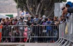 Asylum seekers queue for a turn for an asylum appointment with U.S. authorities, at the U.S.-Mexico El Chaparral crossing port in Tijuana, Mexico, on 