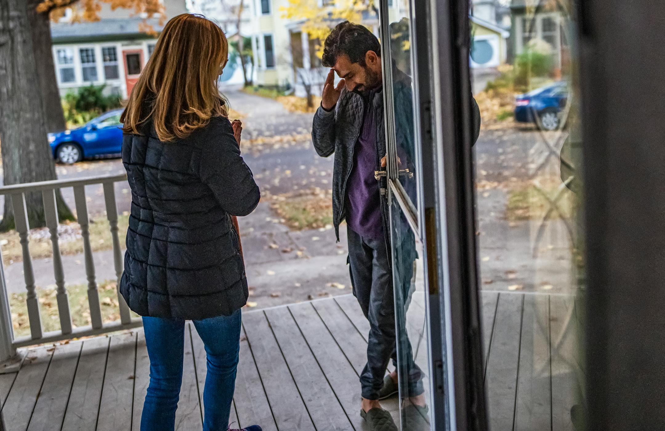 Jane Graupman whose agency the International Institute of Minnesota is helping refugees like Mirwais Momand bids farewell to him after visiting the family of ten in St. Paul.