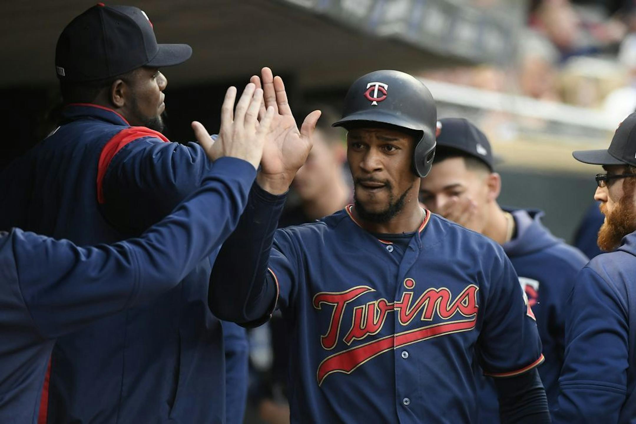 Minnesota Twins center fielder Byron Buxton (25) received high fives from teammates after scoring a run off a triple hit by catcher Mitch Garver (18) in the bottom of the second inning against the Detroit Tigers.