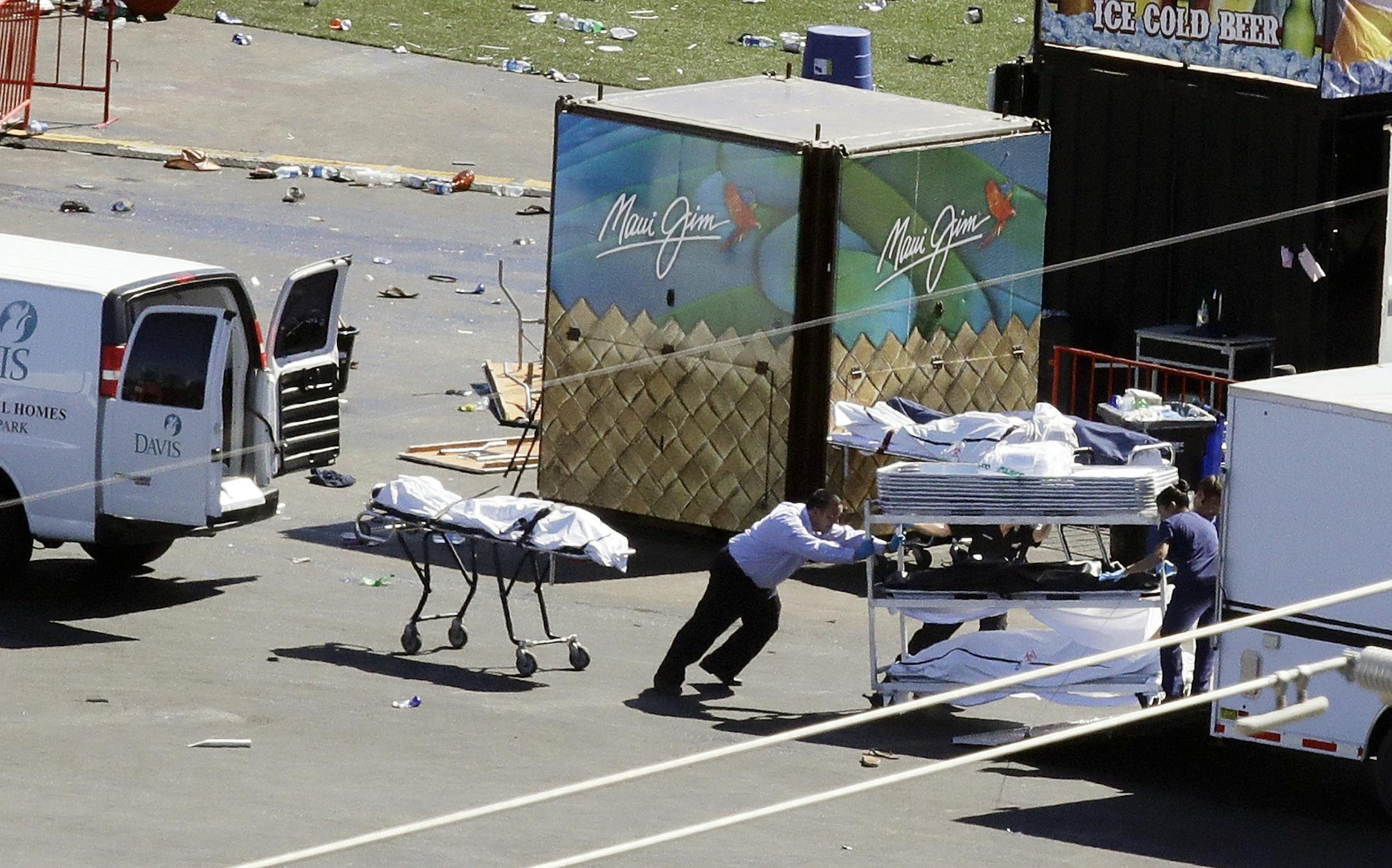 Investigators load a truck next to a body from the scene of a mass shooting at a music festival near the Mandalay Bay resort and casino on the Las Vegas Strip on Monday, Oct. 2, 2017 in Las Vegas.