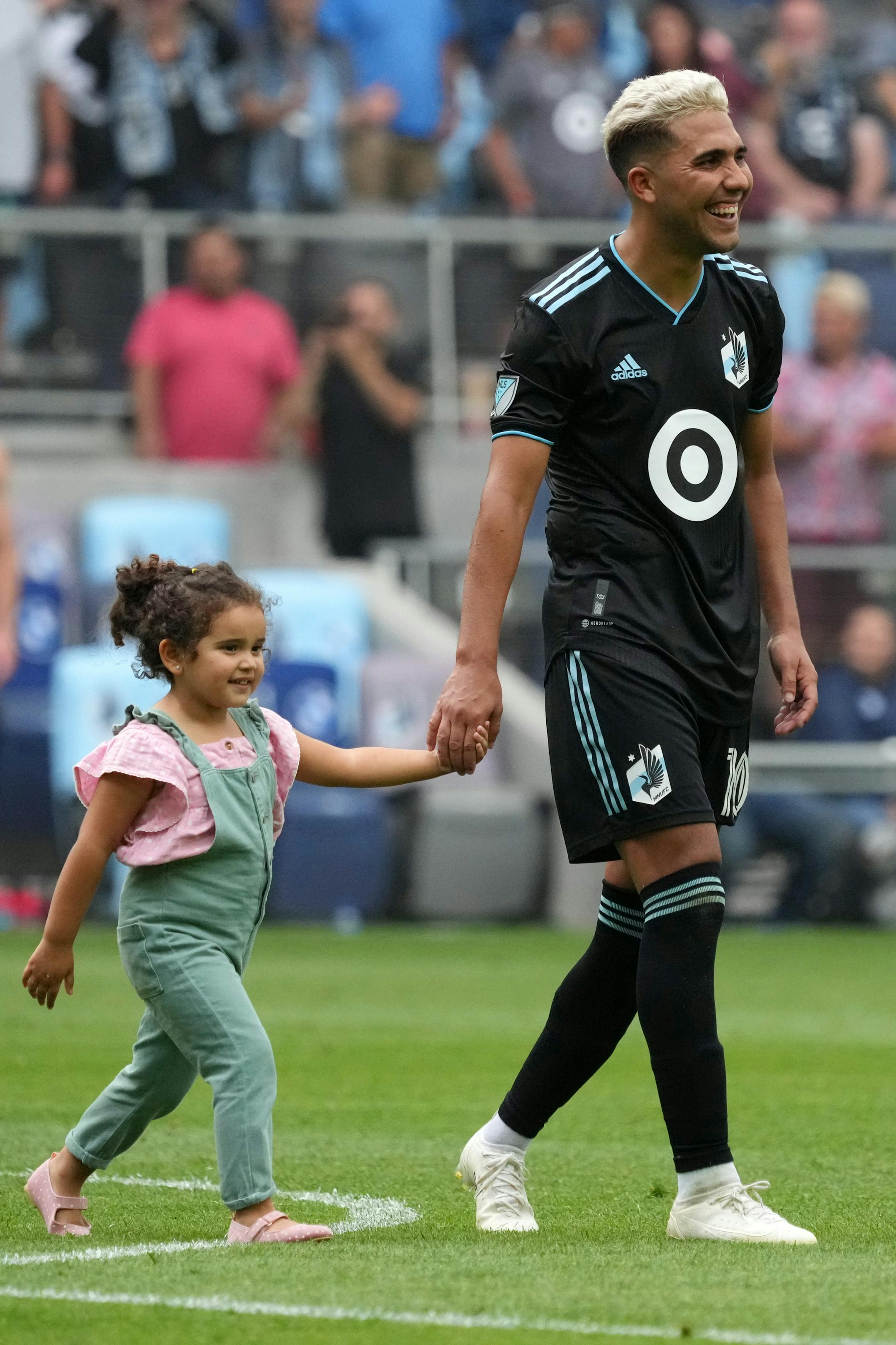 Minnesota United midfielder Emanuel Reynoso (10) walked the field with his daughter following an MLS game between Minnesota United and the Houston Dynamo.