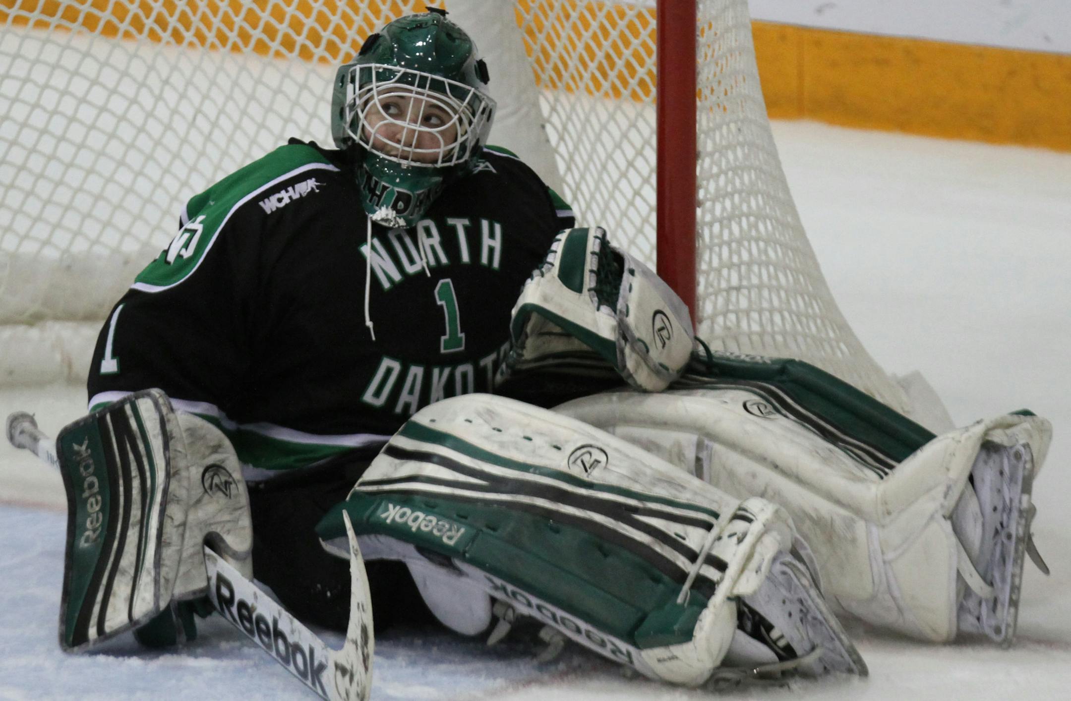 Gopher vs. North Dakota, Ridder Arena, 3/16/13. (left to right) North Dakota goalie Shelby Amsley-Benzie sat dejected after loosing to the Gophers in the 3rd overtime.] Bruce Bisping/Star Tribune bbisping@startribune.com Shelby Amsley-Benzie/roster.