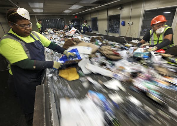 Josefa Calleja, left, and Cecilia Morales worked the presort line at Eureka Recycling in Minneapolis, pulling obvious nonrecyclables from the raw inta