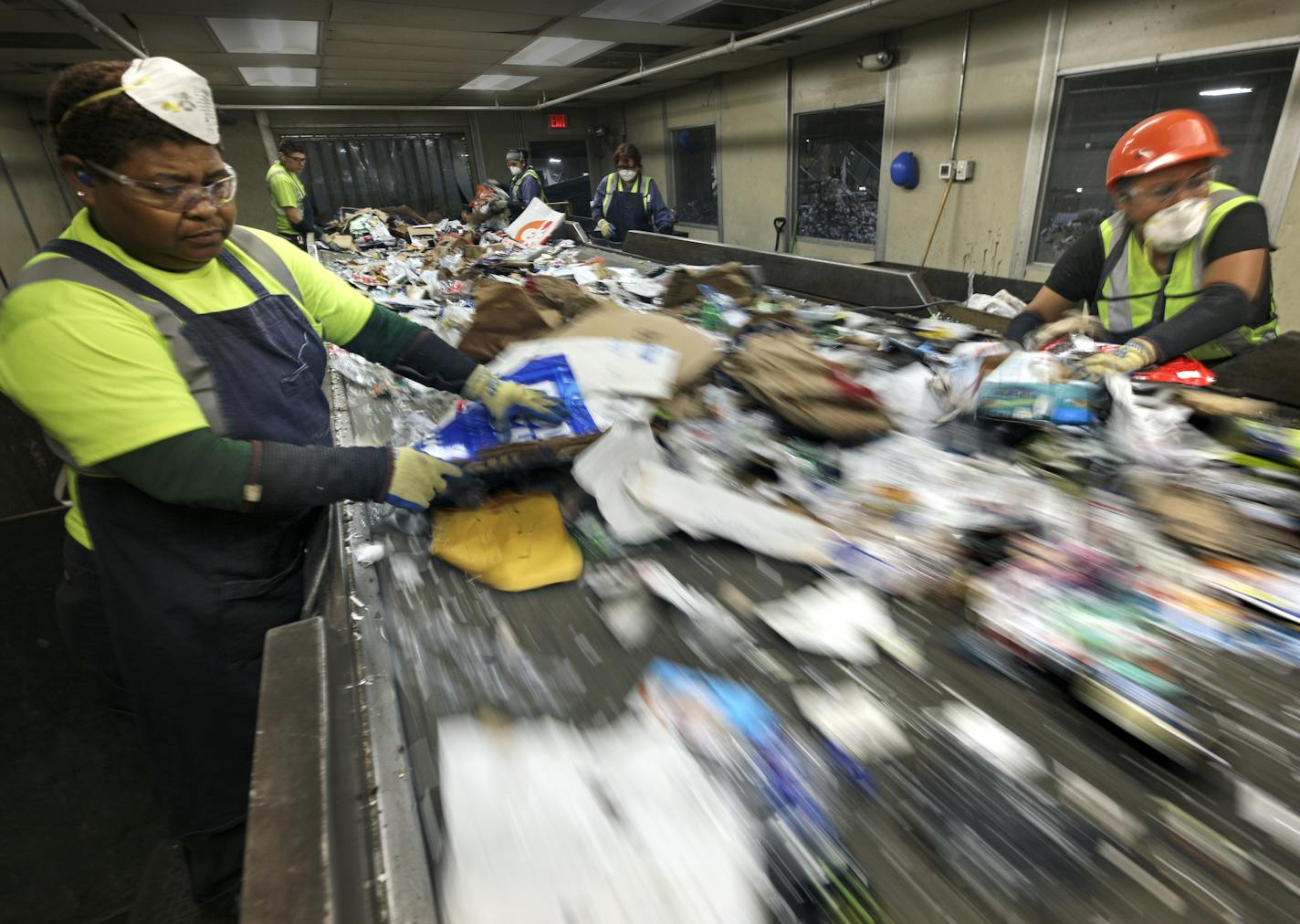 Josefa Calleja, left, and Cecilia Morales worked the presort line at Eureka Recycling in Minneapolis, pulling obvious nonrecyclables from the raw intake.