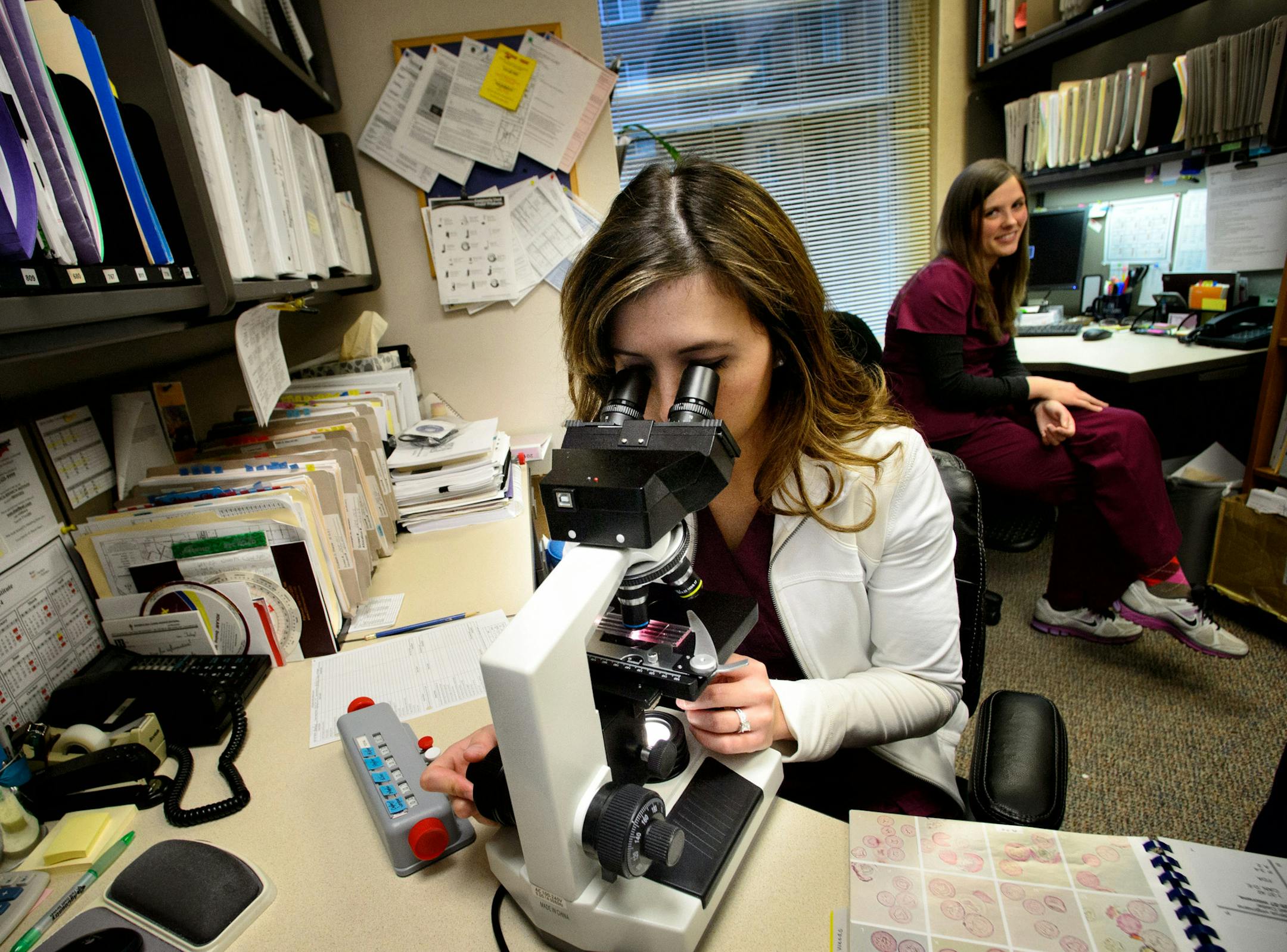 Pollen detective Jenjira Skrei checked pollen samples through a microscope at Clinical Research Institute. Behind her is Krista Sullivan ] Monday, April 28, 2014 GLEN STUBBE * gstubbe@startribune.com