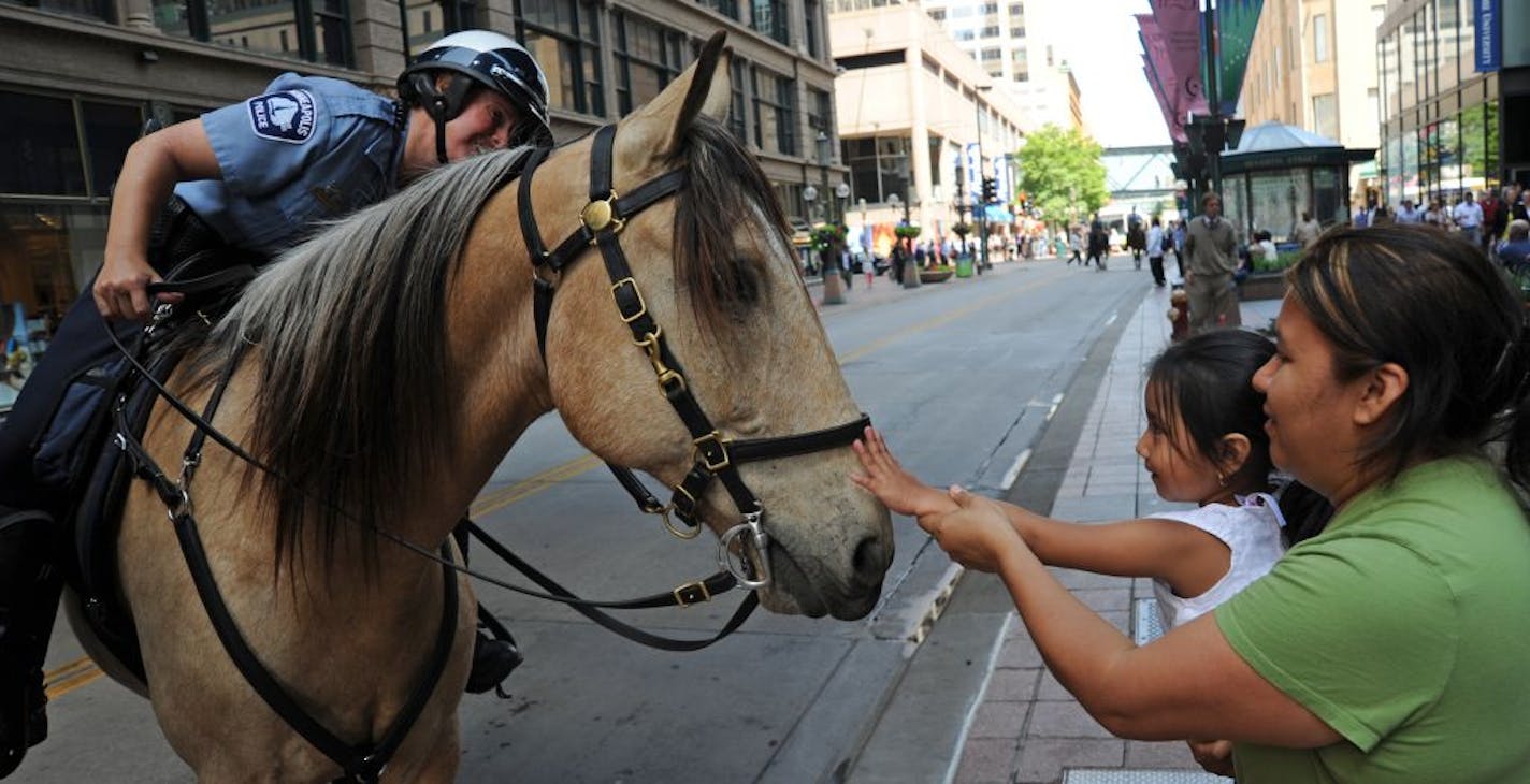 . Anna Centeno, of Minneapolis held her 4-year-old daughter Alexia out to touch Minneapolis mounted patrol Robin Wagner's horse Diego.