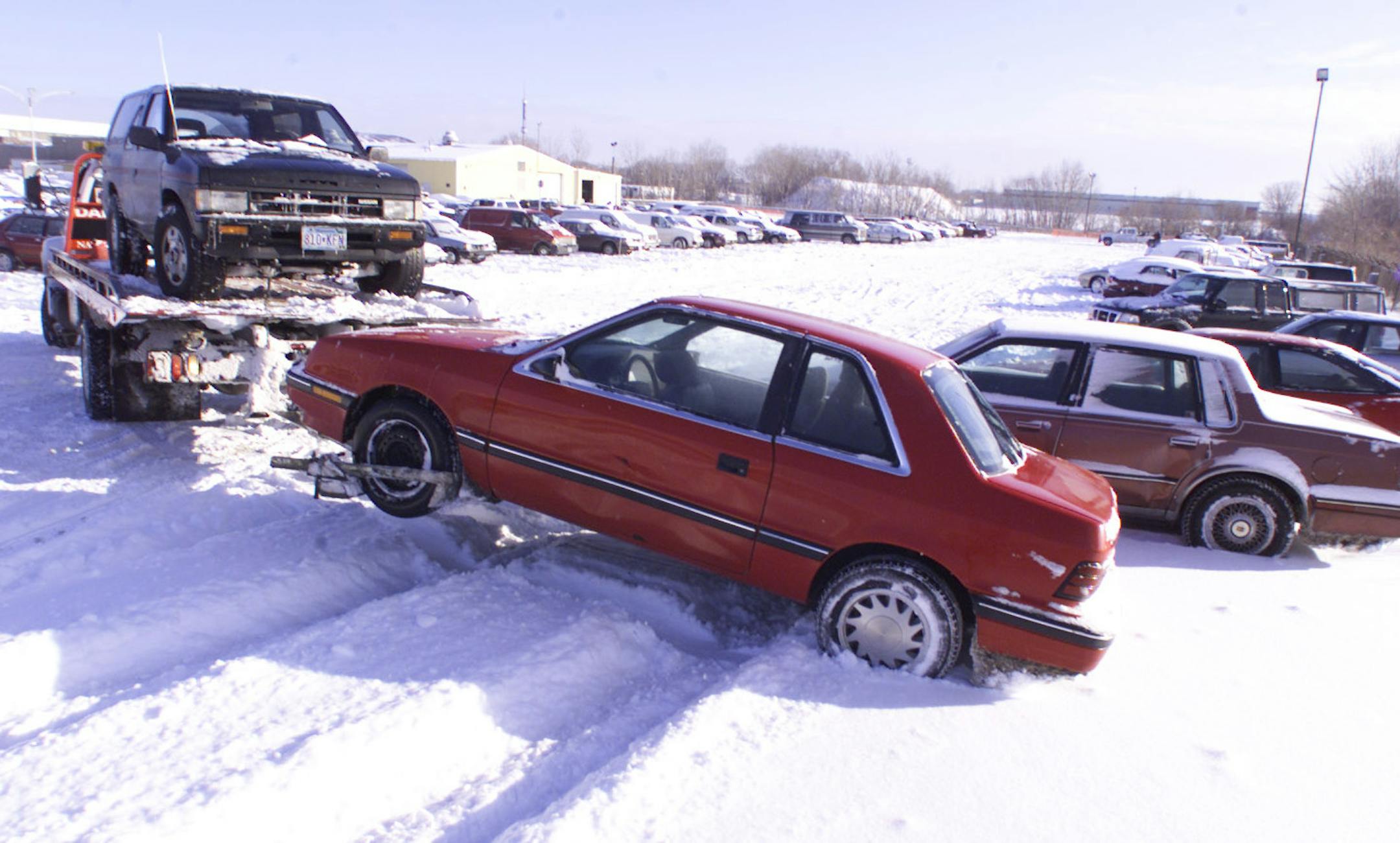 SAINT PAUL, MN - THUR - 1/13/2000 - St Paul declared a snow emergency and lots of vehicles were towed to the St. Paul Car Impound Lot, Como Ave, 2 blocks west of Snelling across from St. Fairgrounds. Tow trucks were busy all morning bringing the snowbirds in and lining them up in neat rows in the the sparkling new fallen snow.