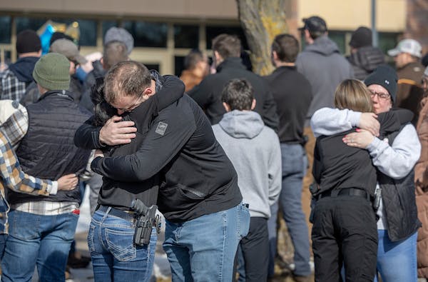 Members of the Burnsville Police Department gathered outside the department's headquarters among three memorials for the slain first responders.