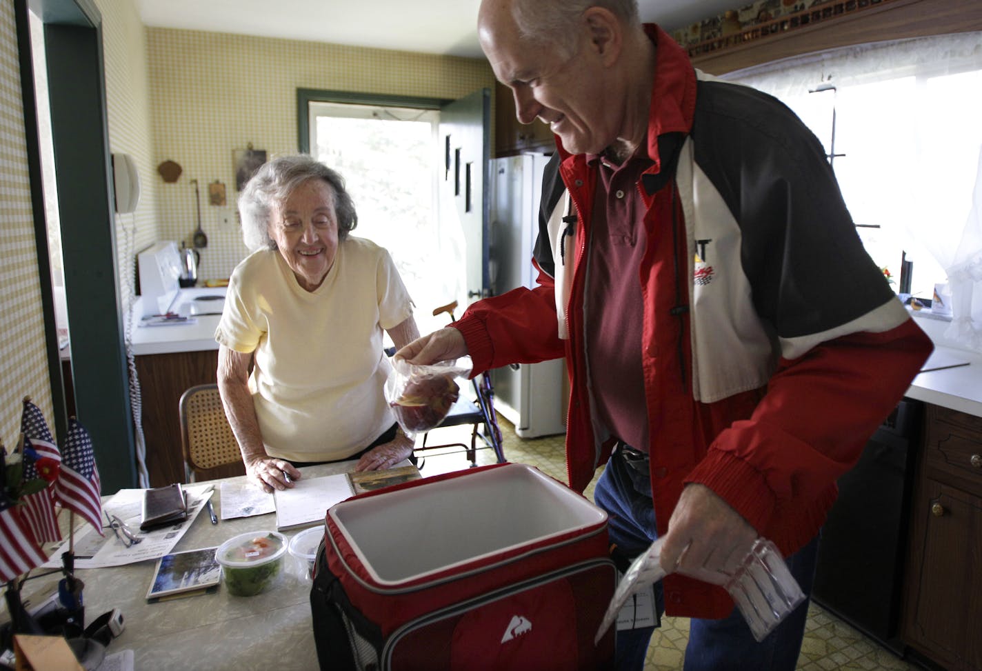 Marty Robertson unpacks food from the Chagrin Falls Meals on Wheels program for recipient Bernadette Winko, 90, in her Bentleyville, Ohio home on Wednesday, March 14, 2012. While Ohio's population growth has been nearly flat, the number of residents 65 and older has increased at a rate of nearly 8 percent, underscoring the growing need for senior services. Many Ohio counties are investing in in-home help, like Meals on Wheels, aimed at enabling older residents to age in their own homes. (AP Phot