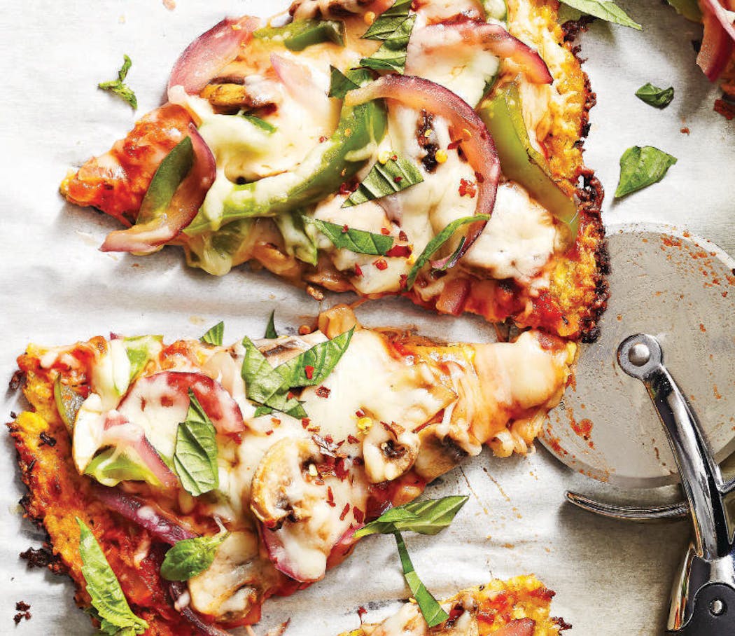 A cauliflower-crusted pizza crust topped with peppers and onions is an approachable way to work more vegetables into a meal.
