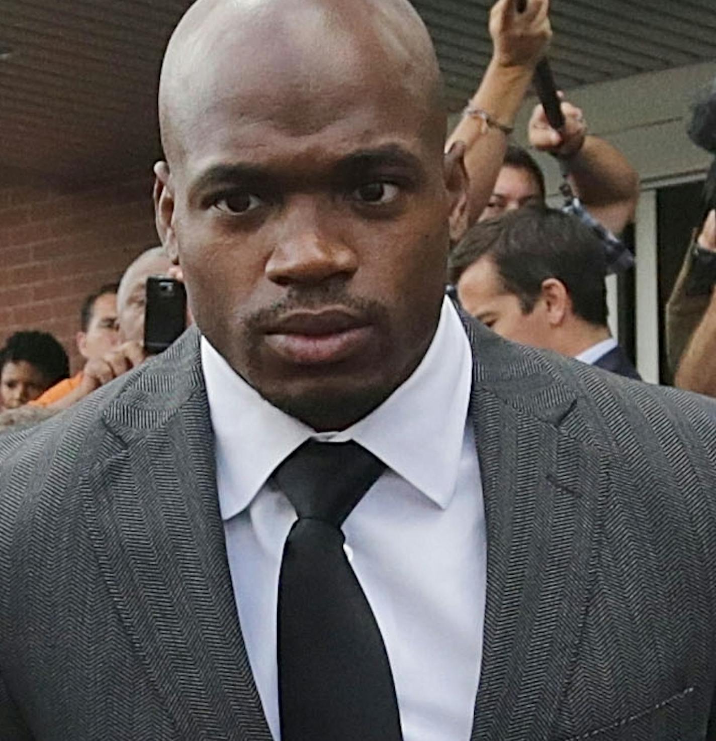 FILE - In this Oct. 8, 2014, file photo, Minnesota Vikings running back Adrian Peterson leaves court accompanied by his wife, Ashley Brown Peterson, in Conroe, Texas. The NFL suspended Adrian Peterson without pay for at least the remainder of the season. The league said Tuesday, Nov. 18, 2014, it informed the Minnesota Vikings running back he will not be considered for reinstatement before April 15 for violating the NFL personal conduct policy. (AP Photo/Houston Chronicle, Billy Smith II, File)