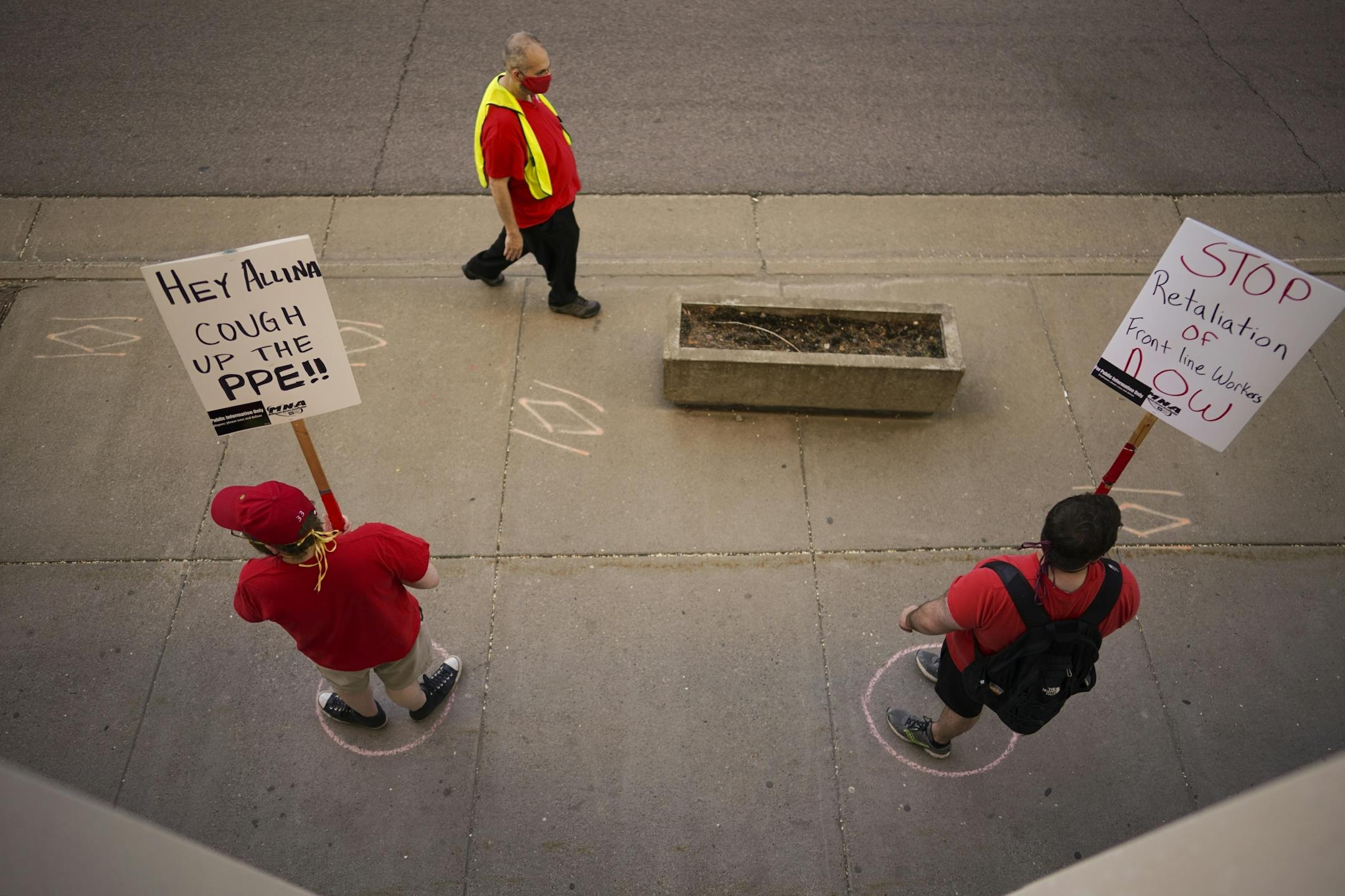 Chalk circles on the sidewalk indicated safe social distancing for the picketers.