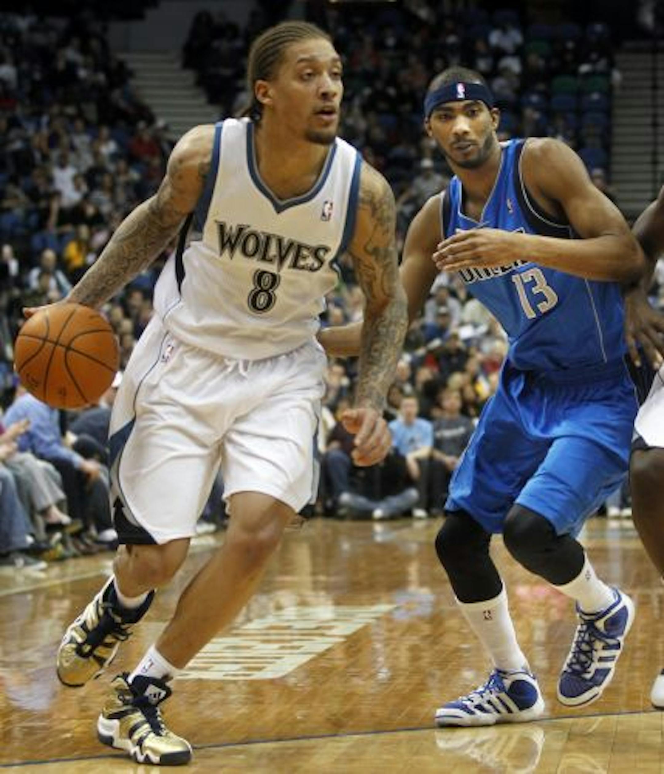 At the Target Center in a game between the Timberwolves and the Mavericks, Michael Beasley(8) drives as Corey Brewer (13) of Dallas tries to get past a pick.