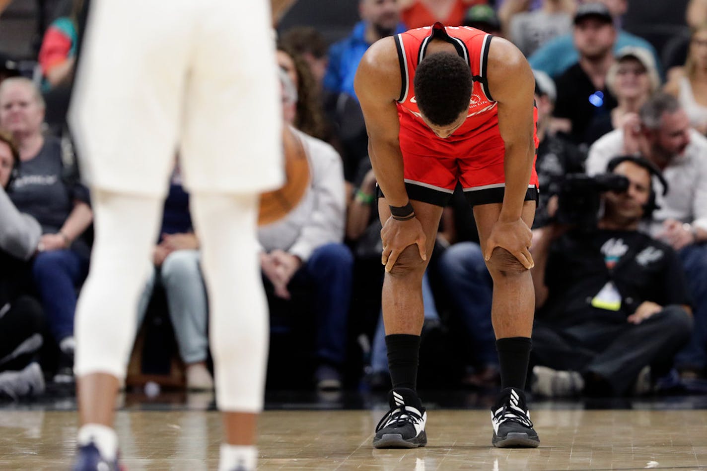 Toronto Raptors guard Kyle Lowry (7) holds his head down as players stop the action o.f a basketball game during the first half against the San Antonio Spurs