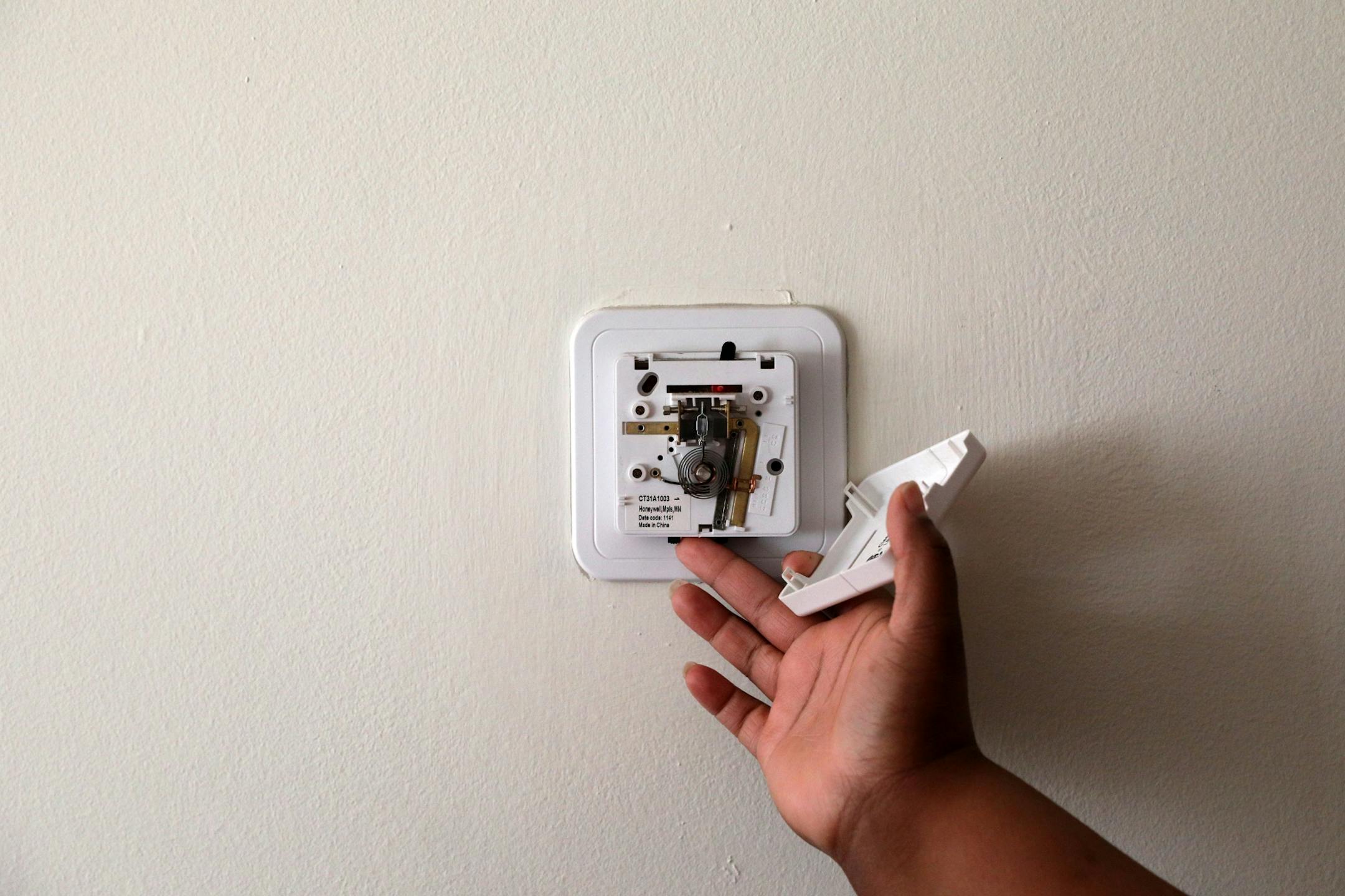 Angelleece Hawkins showed off the inoperative thermostat in her apartment unit.