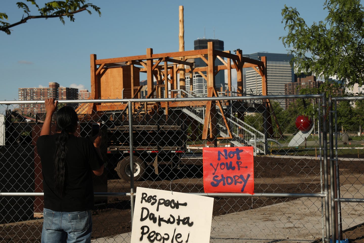 A man at the Minneapolis Sculpture Garden looked though the fence at "Scaffold," by Sam Durant, a piece that depicts the 1862 hangings of 38 Dakota men.