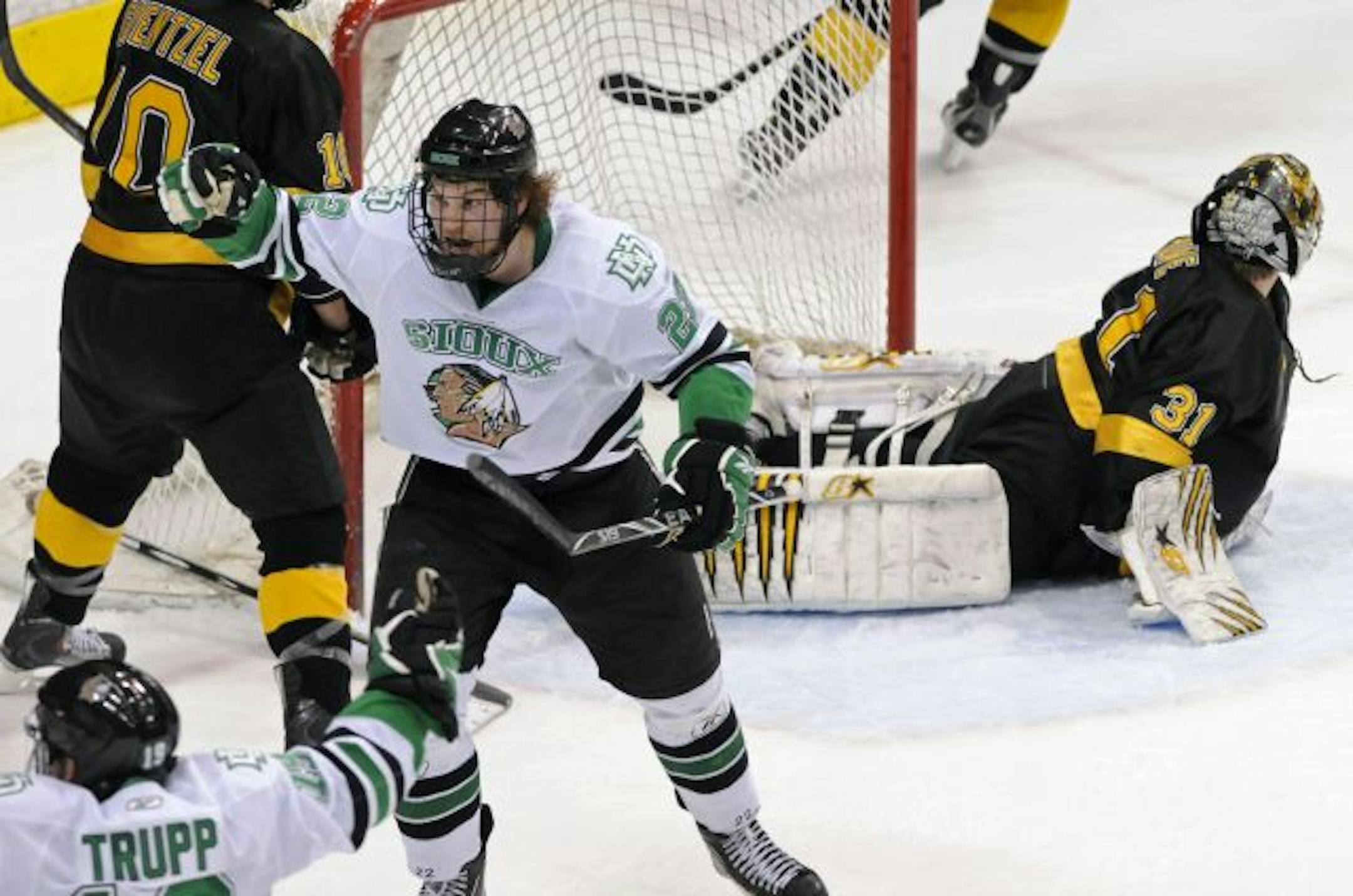 North Dakota's Brad Malone, left, celebrates the go-ahead goal by Matt Frattin against Colorado College goalie Joe Howe, right, in the third period of a WCHA Final Five college hockey game Friday, March 18, 2011 in St. Paul, Minn. Malone also scored a goal in the third as North Dakota went on to win 4-3.