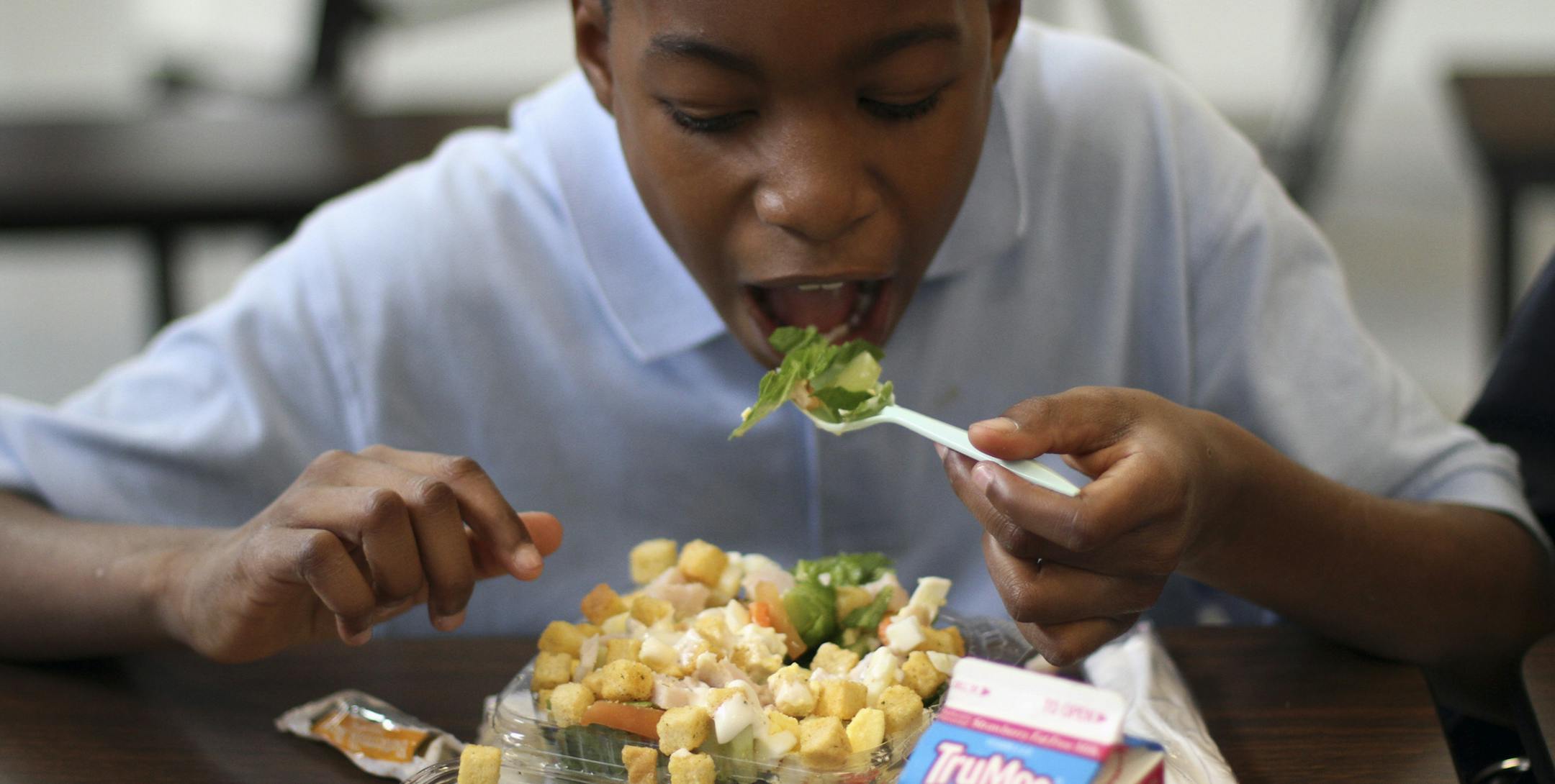 FILE -- Jasir Robinson, 10, eats a salad during lunch at William H. Ziegler Elementary School in Philadelphia, Nov. 20, 2012. American children consumed fewer calories in 2010 than they did a decade before, a new federal analysis shows, but health experts cautioned that the magnitude of the decline was small. (Jessica Kourkounis/The New York Times)