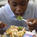 FILE -- Jasir Robinson, 10, eats a salad during lunch at William H. Ziegler Elementary School in Philadelphia, Nov. 20, 2012. American children consum