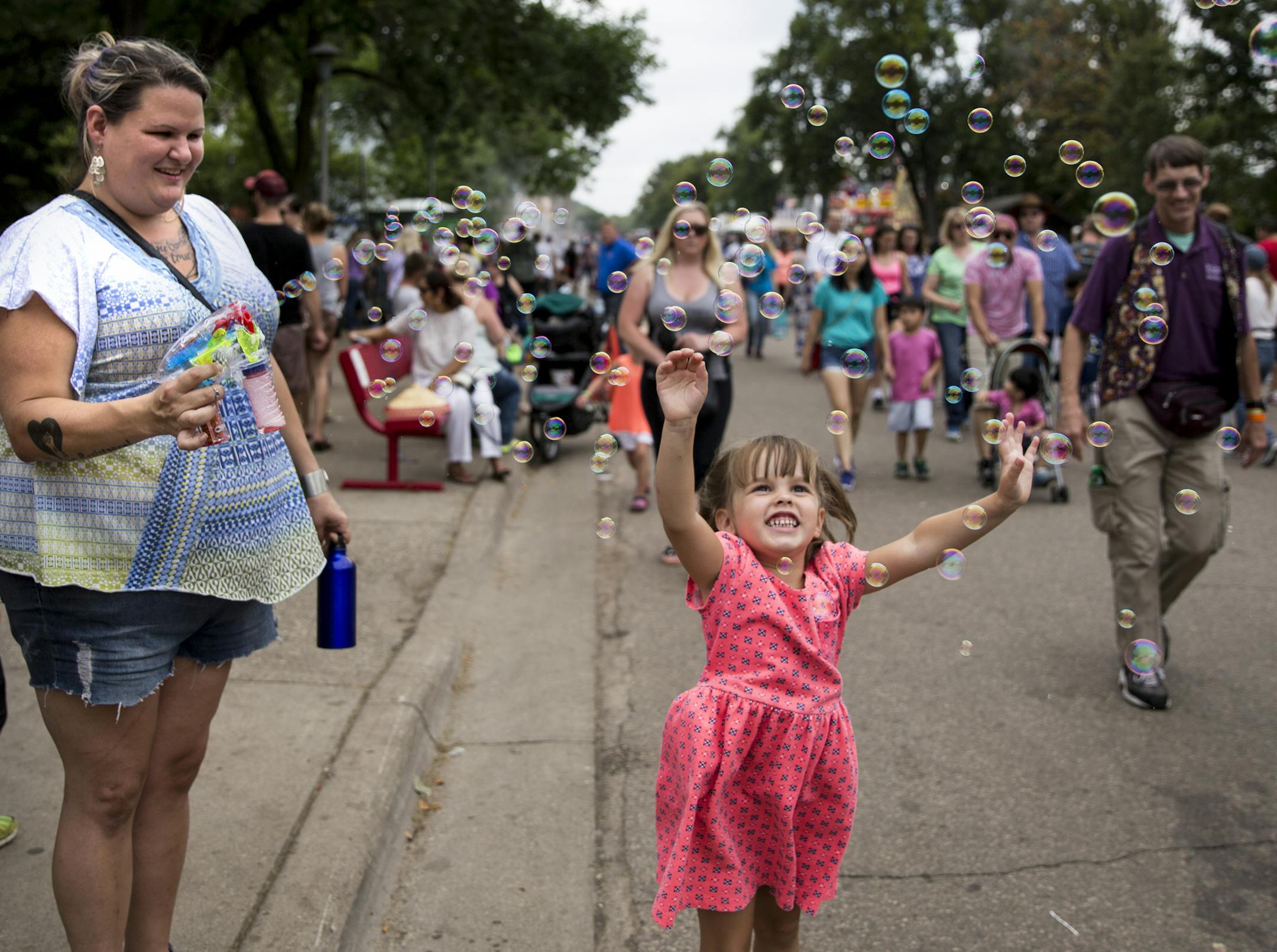 Nicole Morgan, of Burnsville, stood on the curb blowing bubbles onto the road for people walking past to enjoy, a tradition she repeats every year at the fair. Morgan admits some adults don't love her bubble love but she doesn't care. "I just love the smiles I get," said Morgan.