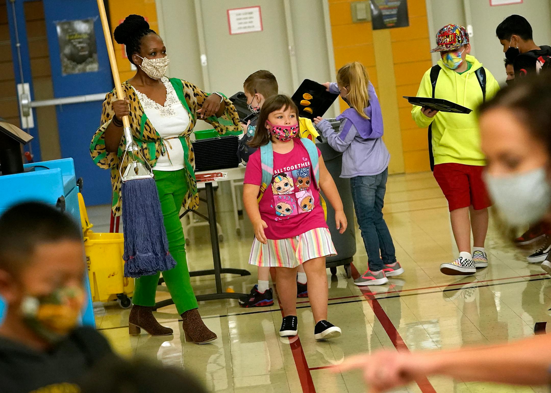 New Hoover Elementary School principal Keisha Davis acted as custodian while grabbing a mop to clean up a spill in the lunchroom during morning breakfast before the start of the first day of school Tuesday in Coon Rapids.   ]
