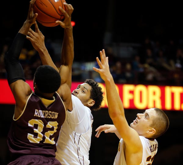 Justin Roberson(32) of Louisiana Monroe goes up for a shot as Jordan Murphy (3) and Joey King (24) of the Gophers defend.