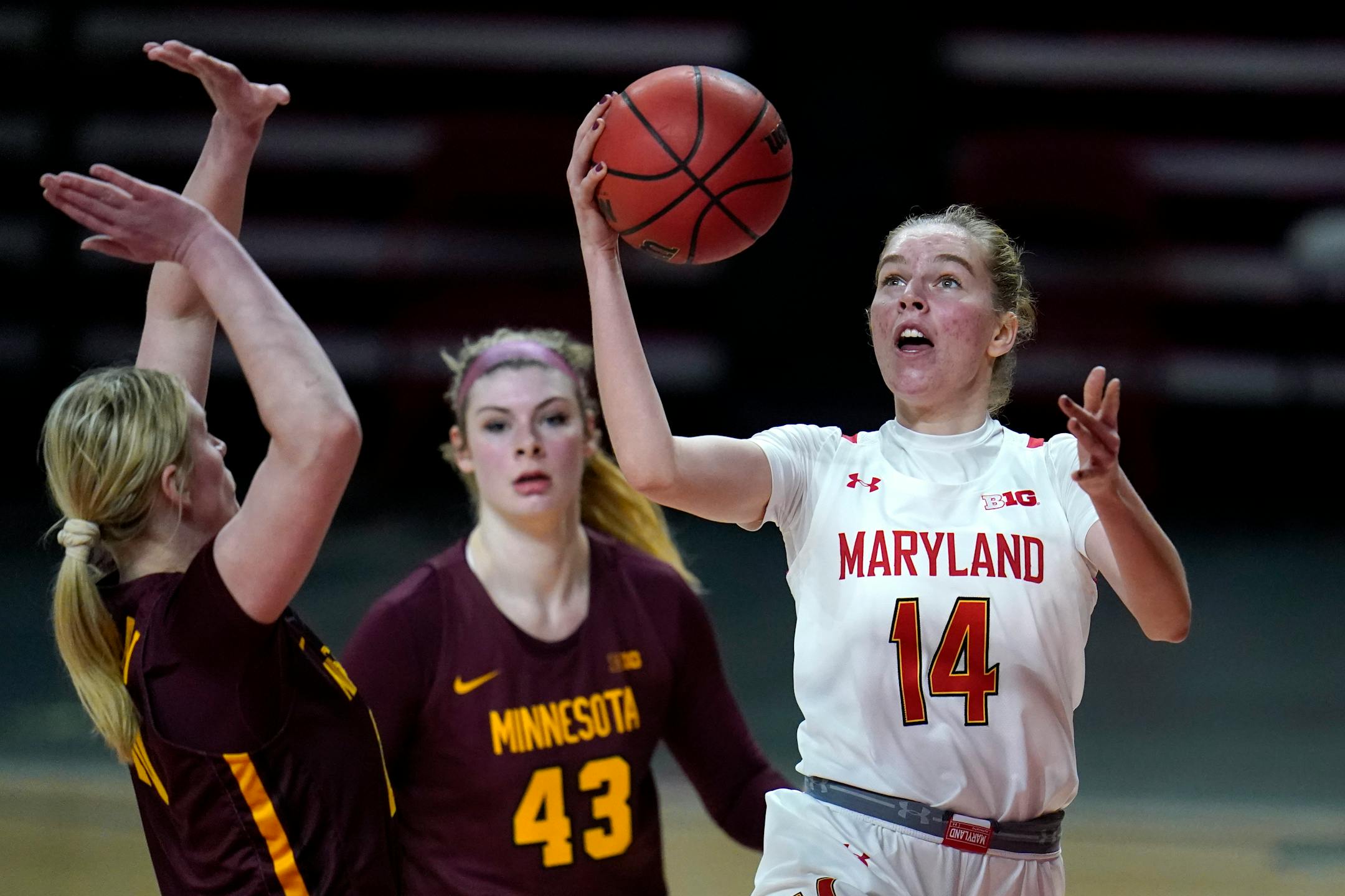 Maryland guard Taisiya Kozlova (14) goes up for a shot against Minnesota forward Erin Hedman, left, and forward Grace Cumming (43) during the second half