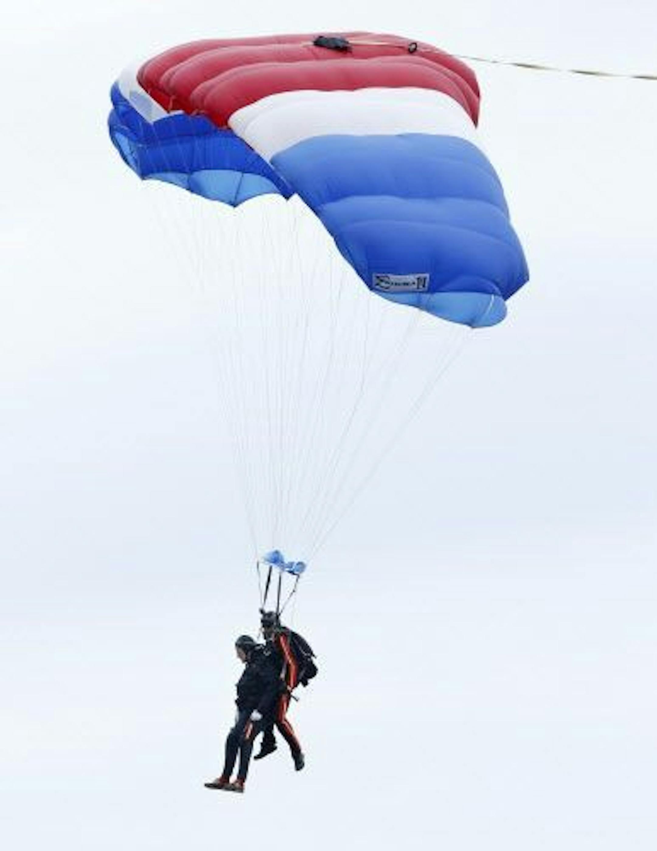 Former President George H.W. Bush, left, strapped to Sgt. 1st Class Mike Elliott, a retired member of the Army's Golden Knights parachute team, float to the ground during a tandem parachute jump near Bush's summer home in Kennebunkport, Maine, Thursday, June 12, 2014.