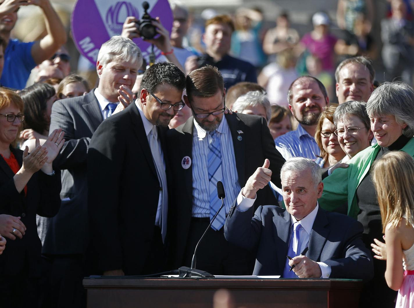 At the State Capitol Governor Mark Dayton signed the gay marriage bill into law in front of several thousand supporters .]rtsong-taatarii@startribune.com