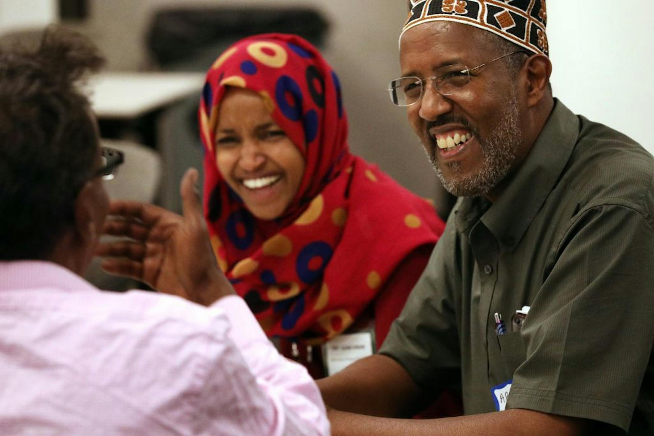 Rep. Ilhan Omar, center, and Abdisalam Adam Dar Al-Hijrah, right, laughed as they talked with Abdirizak Bihi, left, with the Somali Education and Social Advocacy Center following the press conference announcing the end of the measles outbreak.