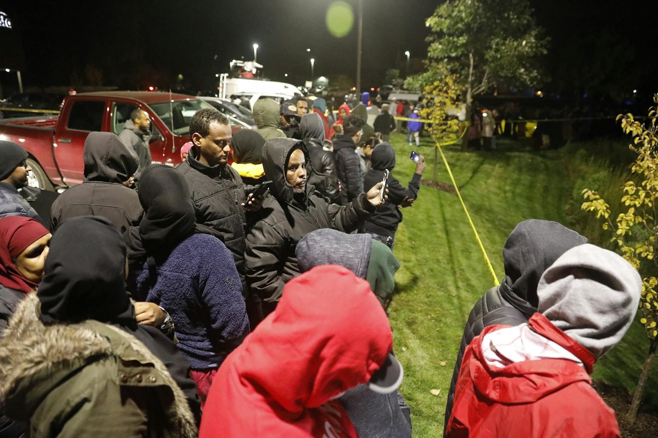 Members of the Somali community gather at the scene.