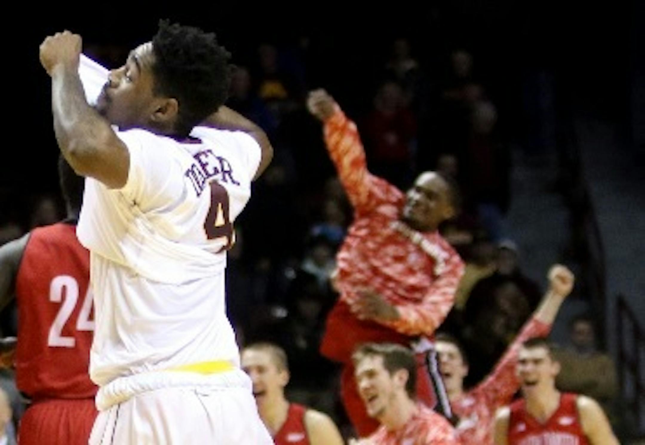 The Gophers' Kevin Dorsey Jr. (4) walked off the court as University of South Dakota players celebrated their 85-81 double overtime win at Williams Arena on Saturday.