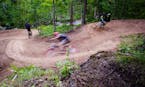 Mountain bikers careen down the Happy Camper trail at Spirit Mountain Bike Park in Duluth. Photo by Hansi Johnson, special to the Star Tribune