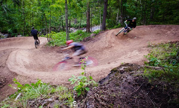 Mountain bikers careen down the Happy Camper trail at Spirit Mountain Bike Park in Duluth. Photo by Hansi Johnson, special to the Star Tribune