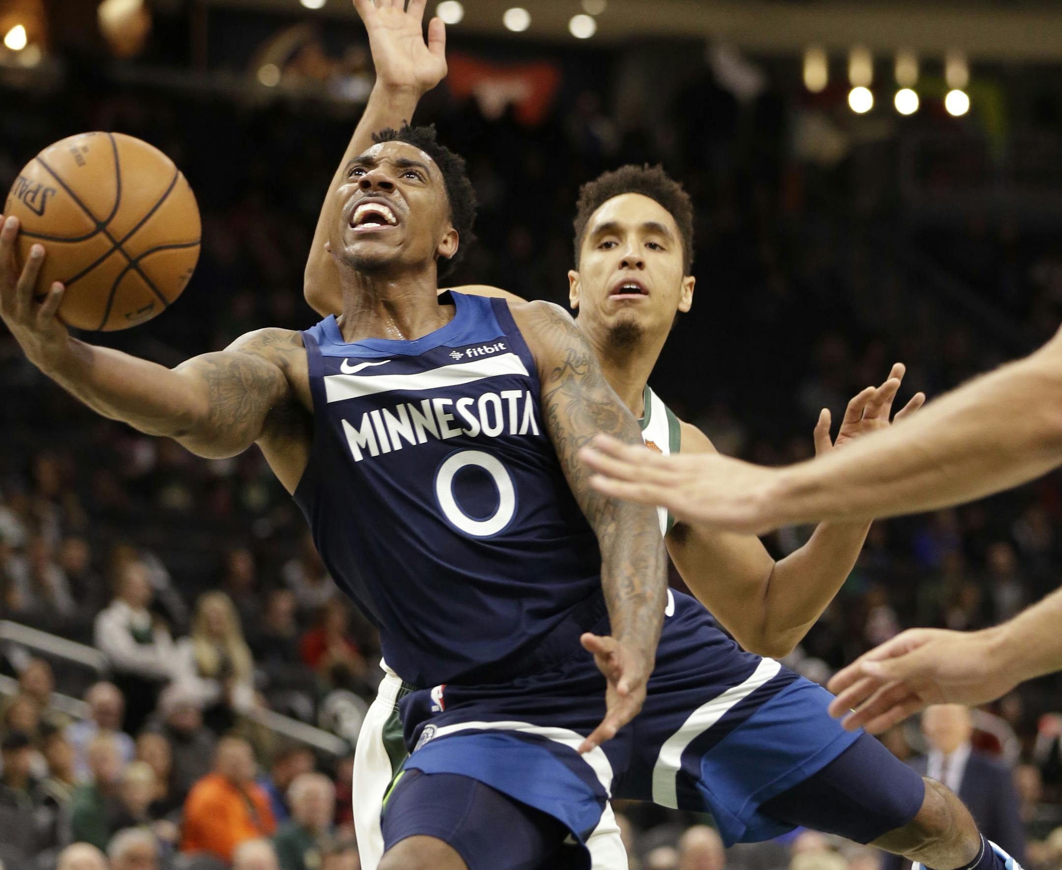 Minnesota Timberwolves guard Jeff Teague gets around the defense of Milwaukee Bucks guard Malcolm Brogdon as he drives to the basket during the first half of an NBA preseason basketball game Friday, Oct. 12, 2018, in Milwaukee. (AP Photo/Mike Roemer)
