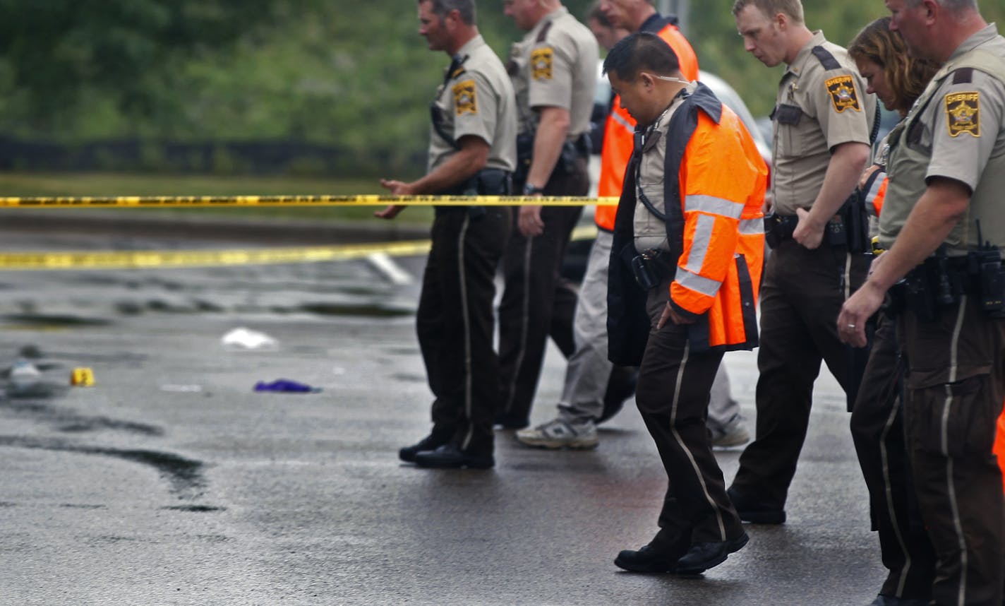 At the Holiday gas startion on HWY 96 near the the 35W exit in Arden Hills on Aug. 11, 2104, investigators examined the evidence at the site of a shooting. The suspect who drove away in a BMW is still at large . ] Richard Tsong-Taatarii/rtsong-taatarii@startribune.com