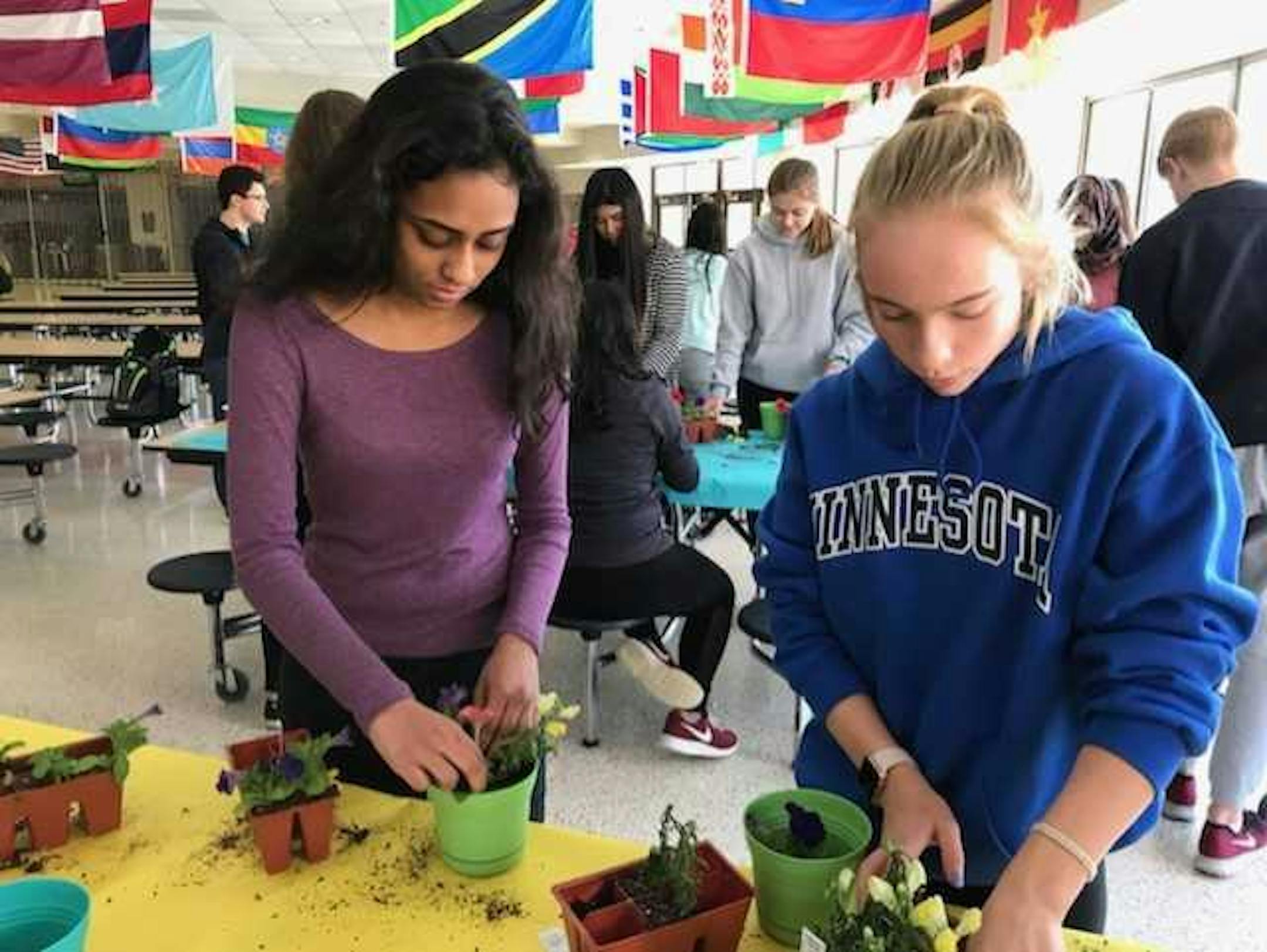 Leo Club members Megha Verghese,15, and Chaney Neulanting,15, plant flowers donated to seniors in assisted living.