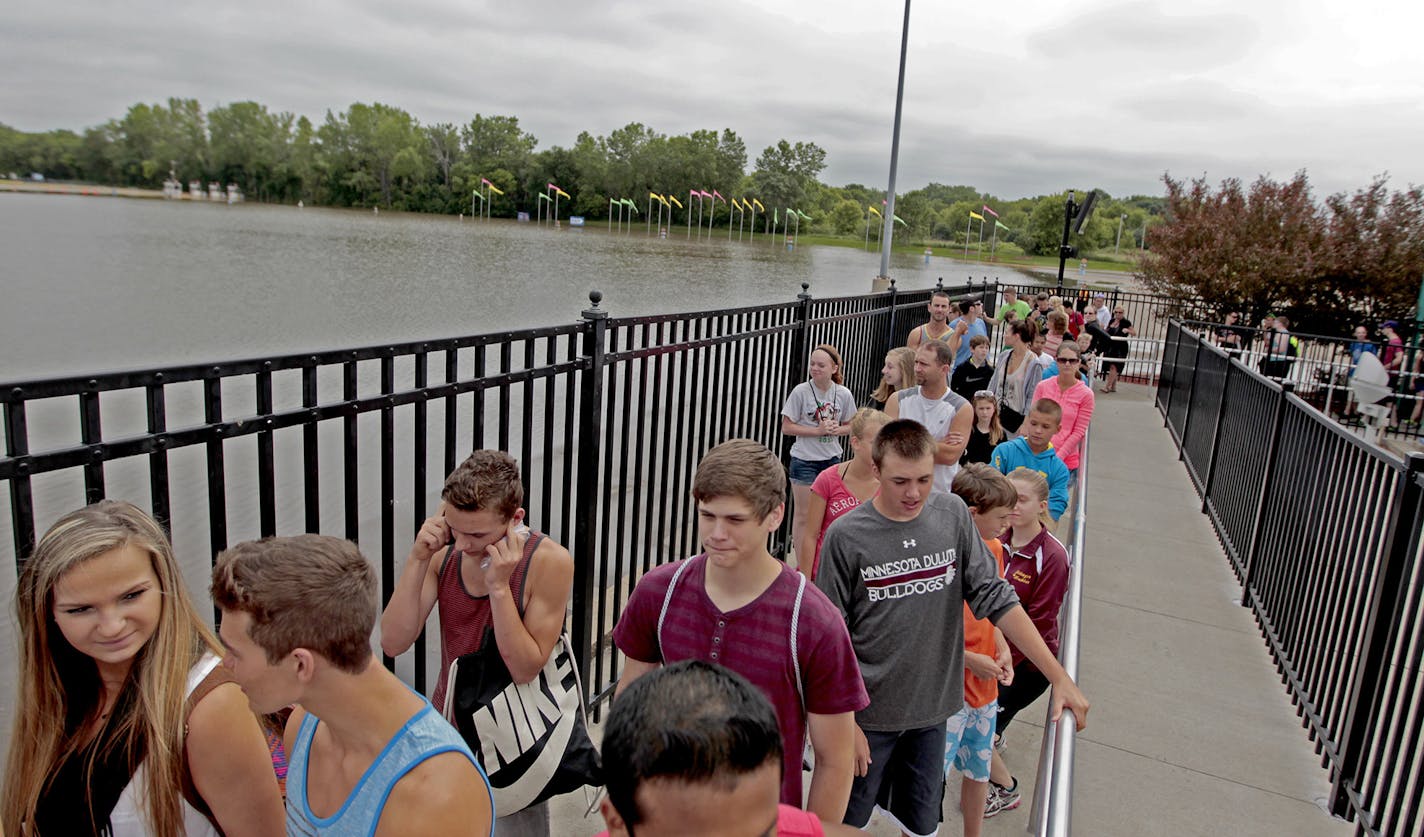 Valleyfair enthusiasts waited to hope on a riide near a flooded parking lot, Wednesday, June 25, 2014 in Shakopee, MN. The parking lot and three rides were closed due to flooding; however, the rest of the park remained open. ] (ELIZABETH FLORES/STAR TRIBUNE) ELIZABETH FLORES &#x2022; eflores@startribune.com