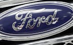 FILE - In this Monday, Jan. 5, 2015, file photo, the Ford logo shines on the front grille of a 2014 Ford F-150, on display at a local dealership in Hi