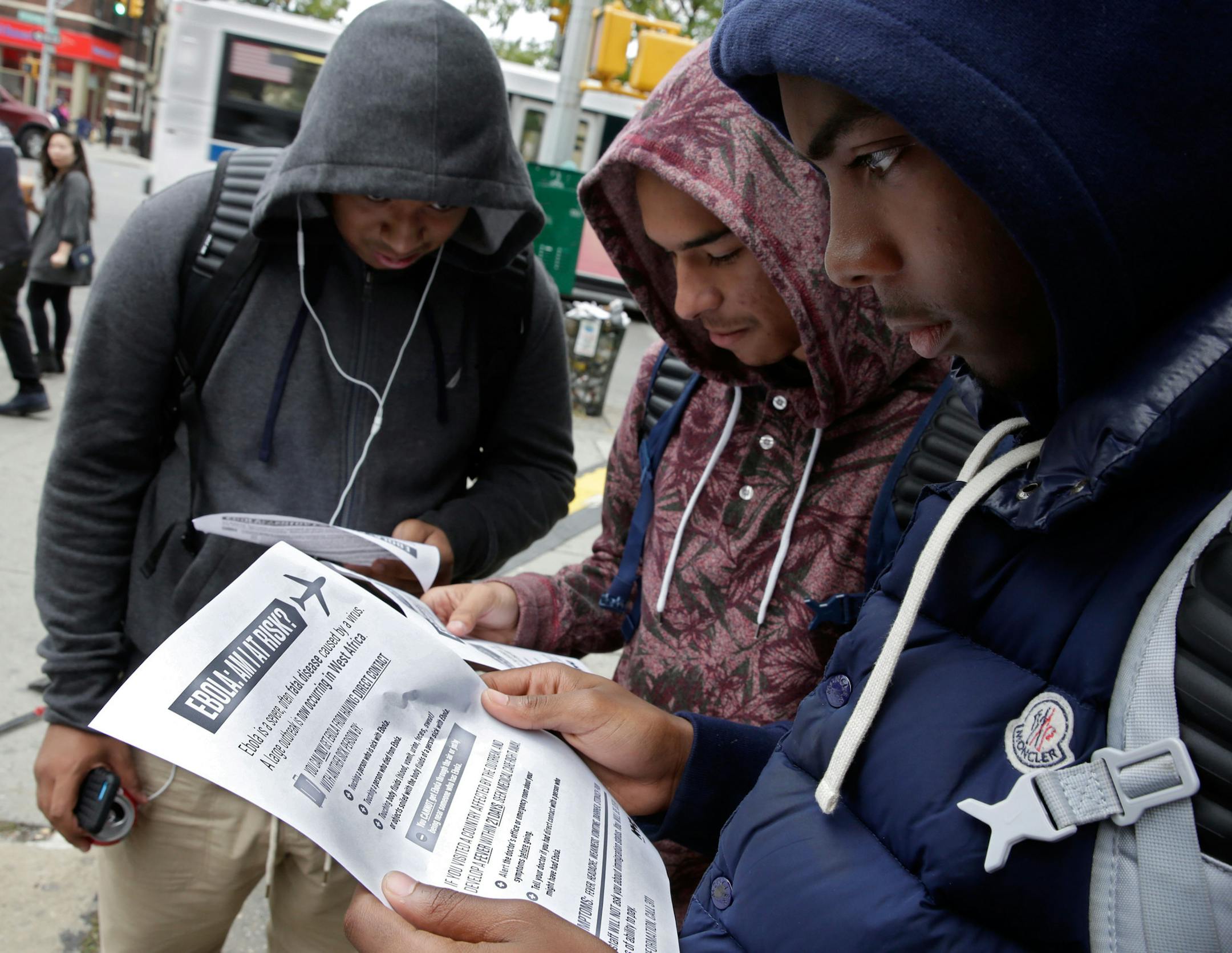 Mott Hall High School student Brian Binion, right, and fellow students read fliers about Ebola risk, near the apartment building of Ebola patient Dr. Craig Spencer, in New York, Friday, Oct. 24, 2014. Since there's no specific treatment, care is focused on easing symptoms to give the body enough time to fight off an infection, (AP Photo/Richard Drew) ORG XMIT: MIN2014102418345601 ORG XMIT: MIN1410241840374880