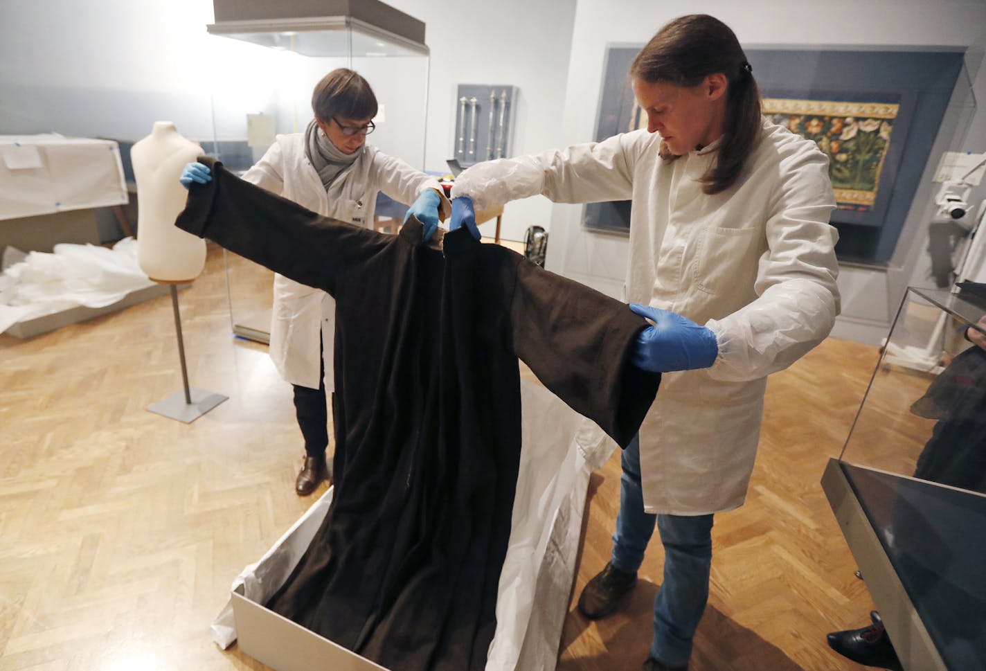 Unpacking the past: German conservators Eva D&#xfc;llo, left, and Andrea Kn&#xfc;pfer, took out a 16th-century monk&#x2019;s robe Thursday for the exhibit.