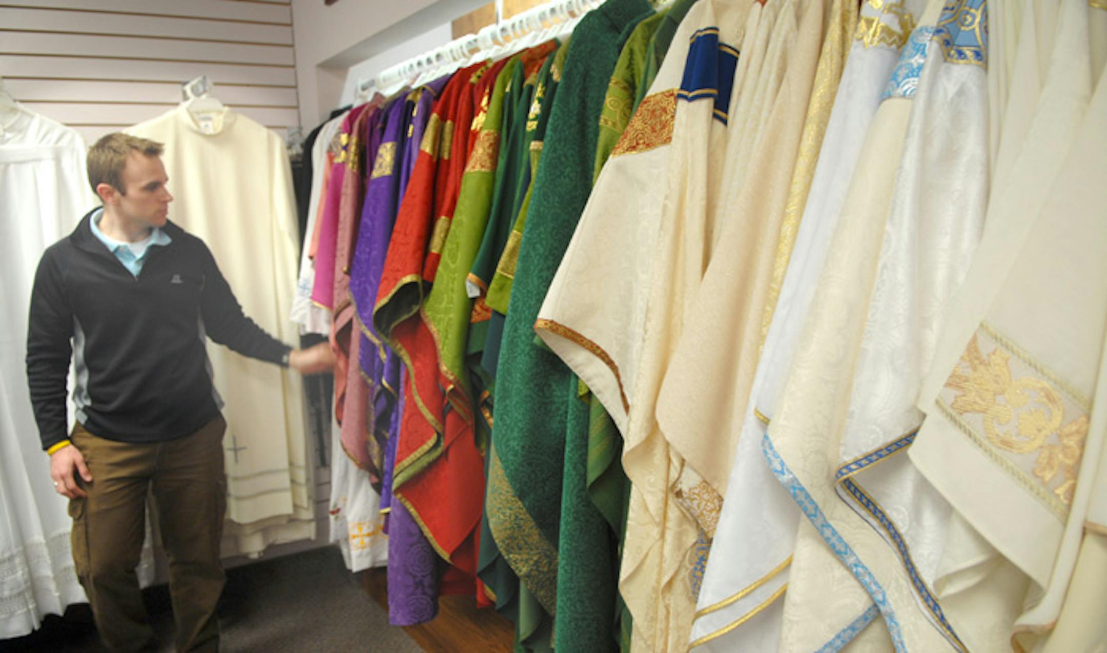 Andrew Shorr looked over some vestments in the church goods section of the showroom. Priests across the nation turn to Leaflet Missal for their vestments. In recent years, more priests are requesting older-style garments, the owner says.