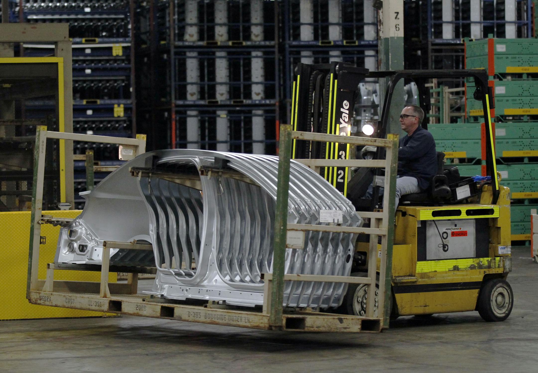 In this Wednesday, April 4, 2012, photo, a worker at the Ford Stamping Plant moves a stack of Lincoln MKS body sides in Chicago Heights, Ill. The U.S. economy grew at a 1.7 percent annual rate in the April-June 2012 quarter, boosted by slightly stronger consumer spending and greater imports. (AP Photo/Charles Rex Arbogast) ORG XMIT: MIN2012082916175412