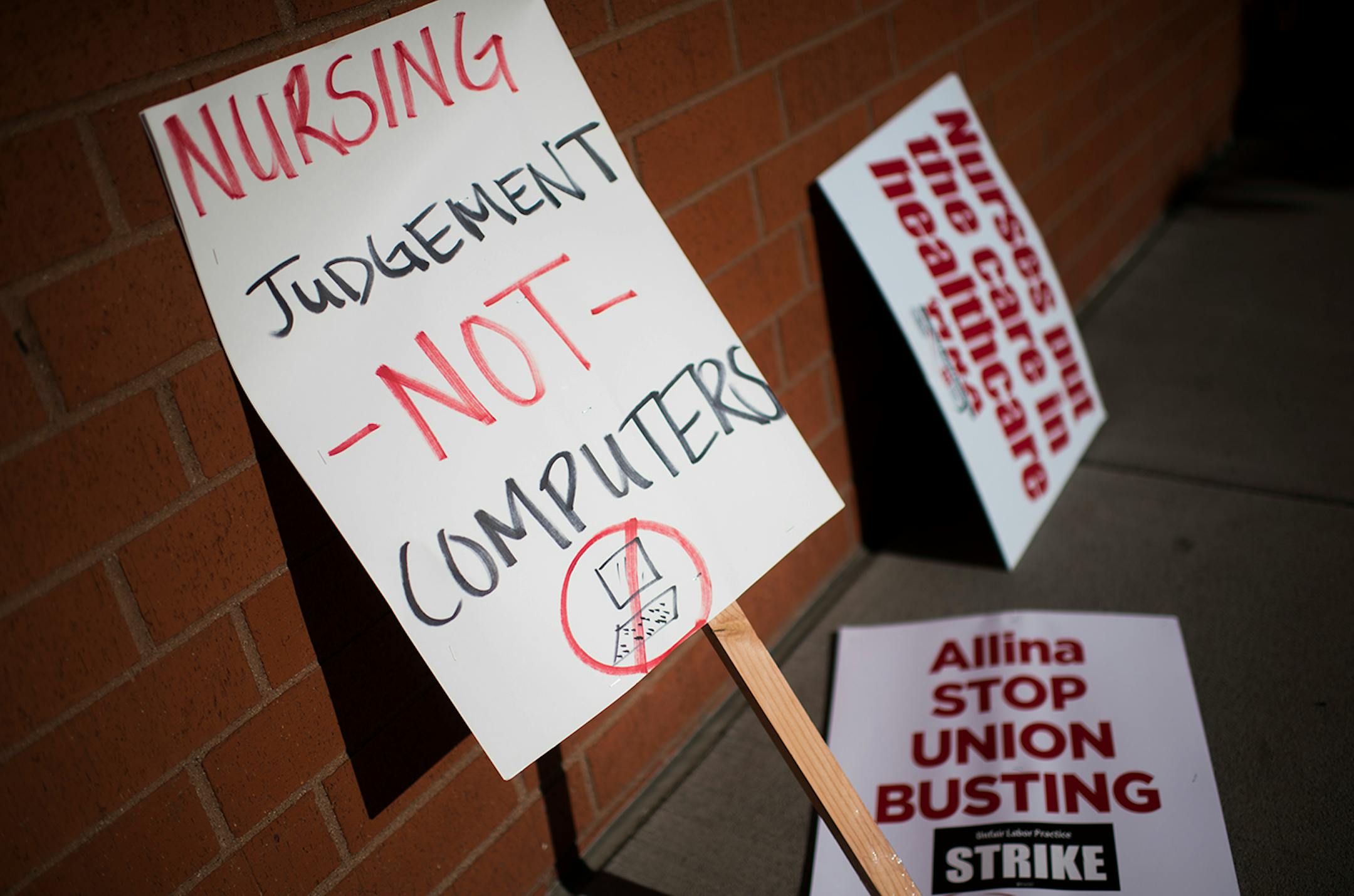 Signs sit along a wall in front of United Hospital in St. Paul.