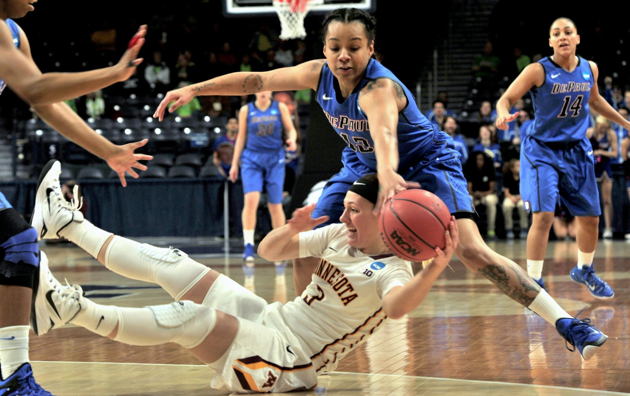 Minnesota guard Shayne Mullaney, bottom, battles for a loose ball with DePaul guard Brittanny Hrynko (12) during the first half of a women's college basketball game in the first round of the NCAA tournament in South Bend, Ind., Friday, March 20, 2015. (AP Photo/Joe Raymond)