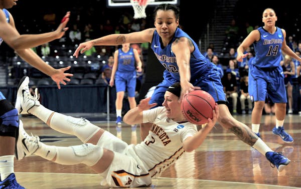 Minnesota guard Shayne Mullaney, bottom, battles for a loose ball with DePaul guard Brittanny Hrynko (12) during the first half of a women's college b