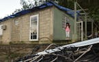 In this Dec. 22, 2017 photo, six year old Melanie Oliveras Gonz&#xb7;lez stand on the porch of her house, in front of a handful of electric cables kno
