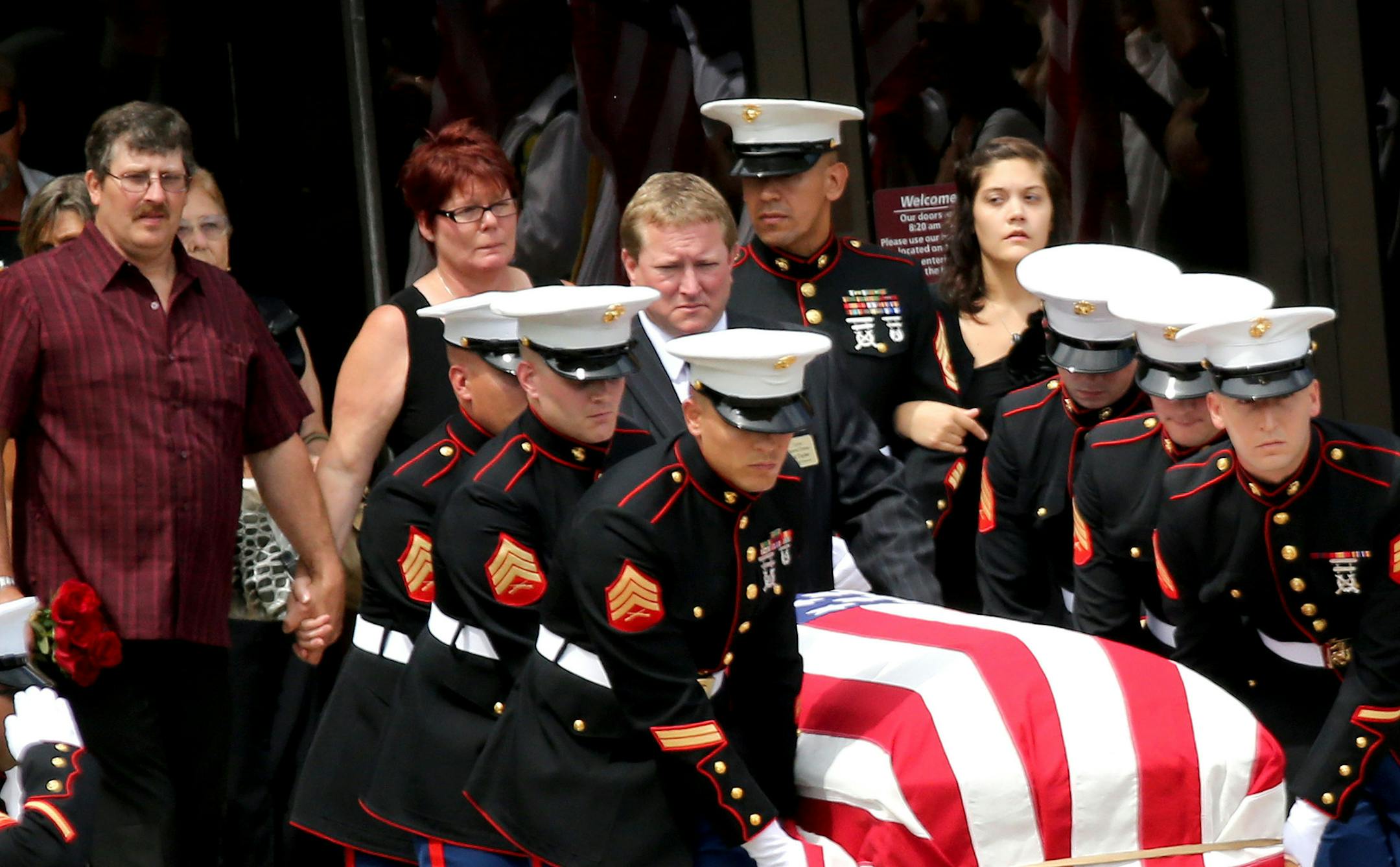 Grantsburg, Wisconsin said goodbye to U.S. Marine Sgt. Carson Holmquist, 25, with a visitation and public funeral at the Grantsburg High School Saturday, July 24, 2015, in Grantsburg, WI. Here, Holmquist's casket is brought from the school followed by Tom Holmquist, rear, left to right, Carson's father and his stepmother Sue Holmquist and Carson's wife Jasmine, rear, right. ](DAVID JOLES/STARTRIBUNE)djoles@startribune.com Grantsburg, Wisconsin said goodbye to U.S. Marine Sgt. Carson Holmquist wi