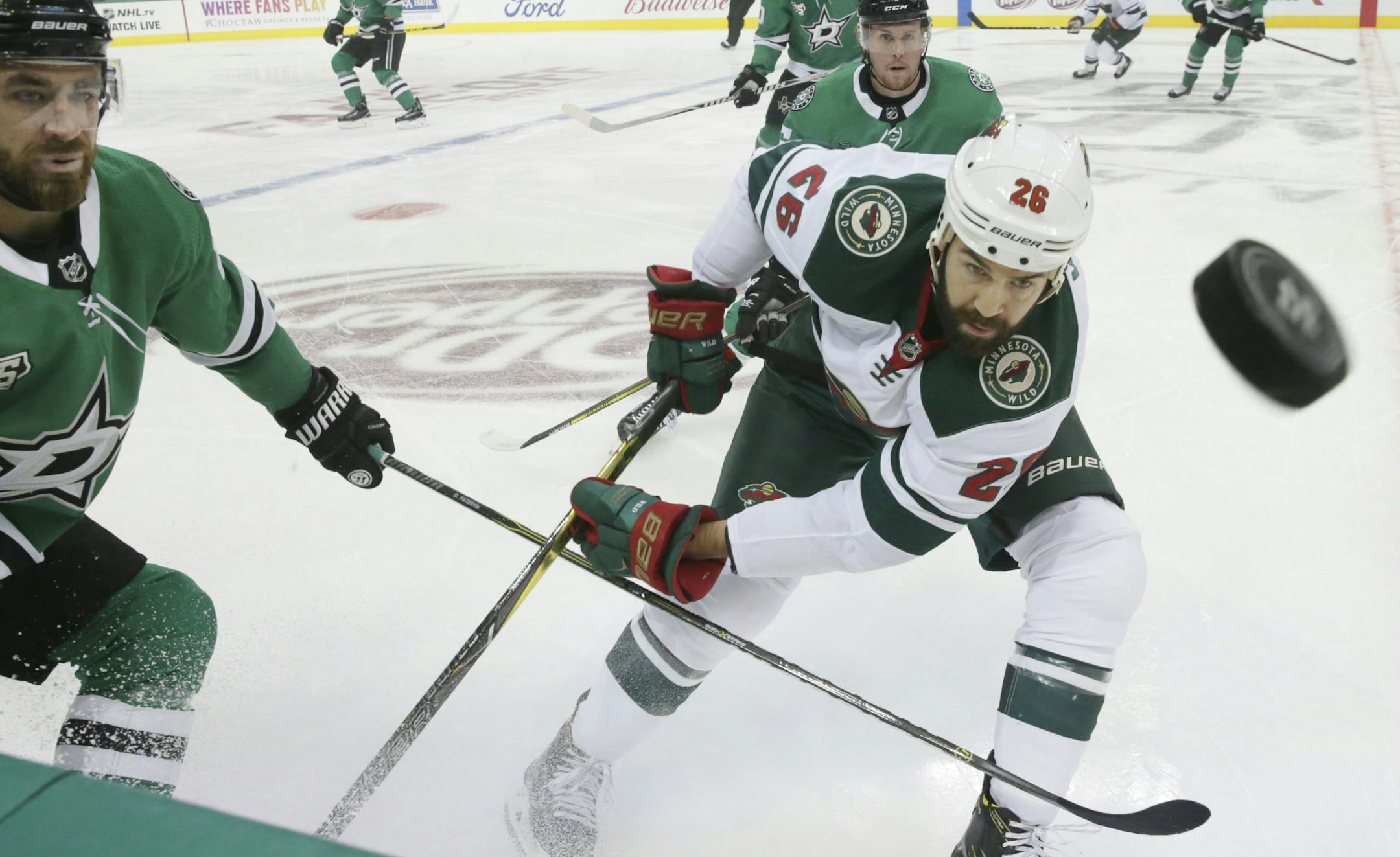 Minnesota Wild right wing Daniel Winnik (26) and Dallas Stars defenseman Greg Pateryn (29) chase the puck during the first period of a preseason NHL hockey game in Dallas, Tuesday, Sept. 26, 2017. (AP Photo/LM Otero)