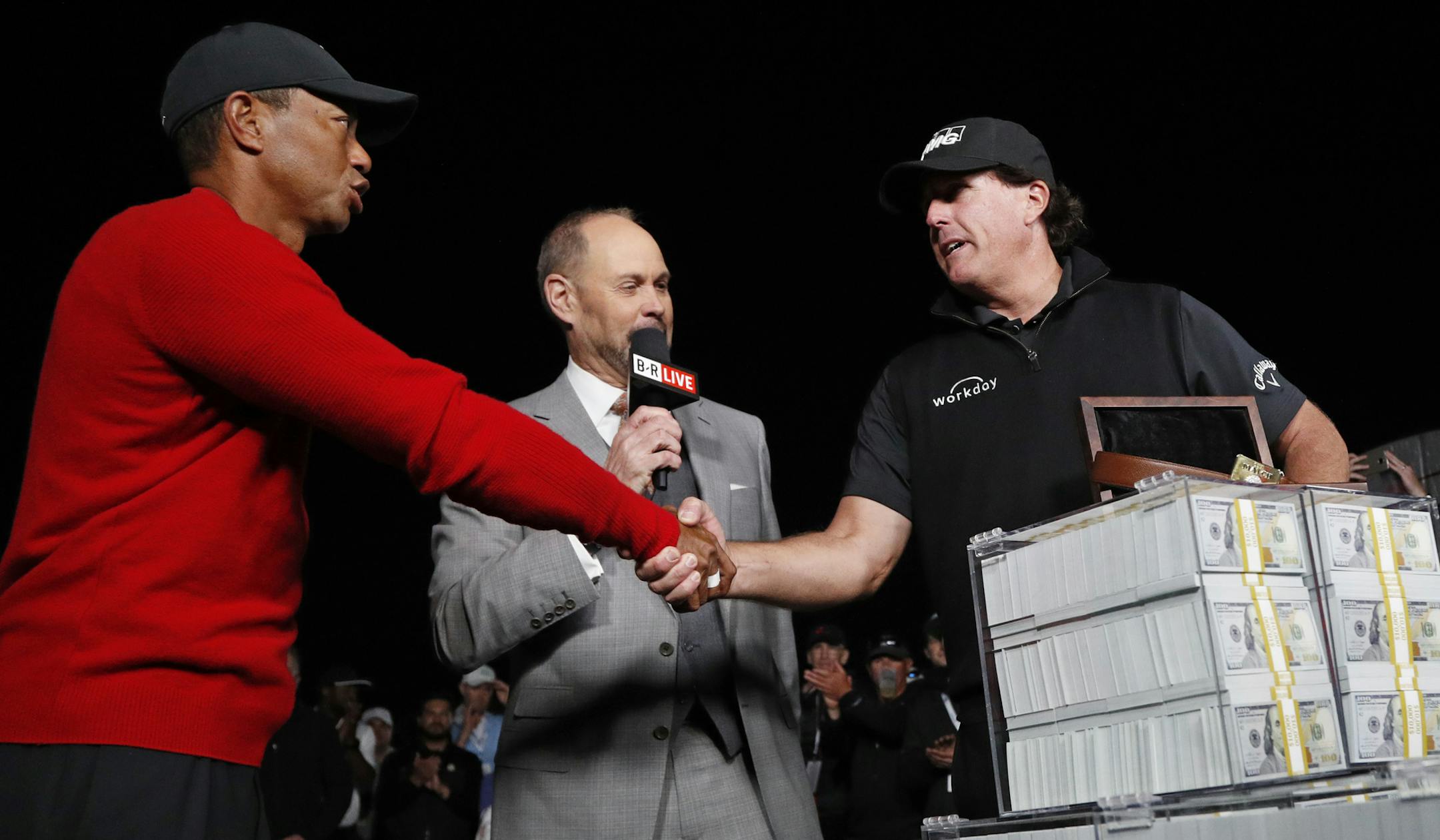 Tiger Woods, left, shakes hands after losing a golf match to Phil Mickelson, right, at Shadow Creek golf course, Friday, Nov. 23, 2018, in Las Vegas. (AP Photo/John Locher)